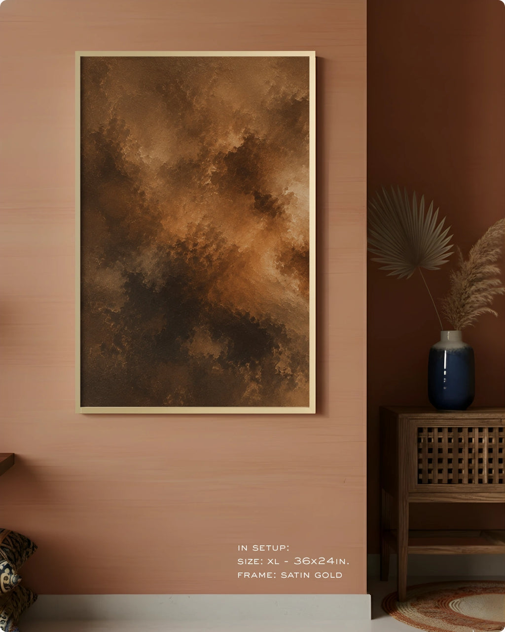 A framed abstract wall art print hangs on a warm terracotta wall in a styled interior. The artwork features a textured, painterly composition in earthy brown, bronze, and gold tones.