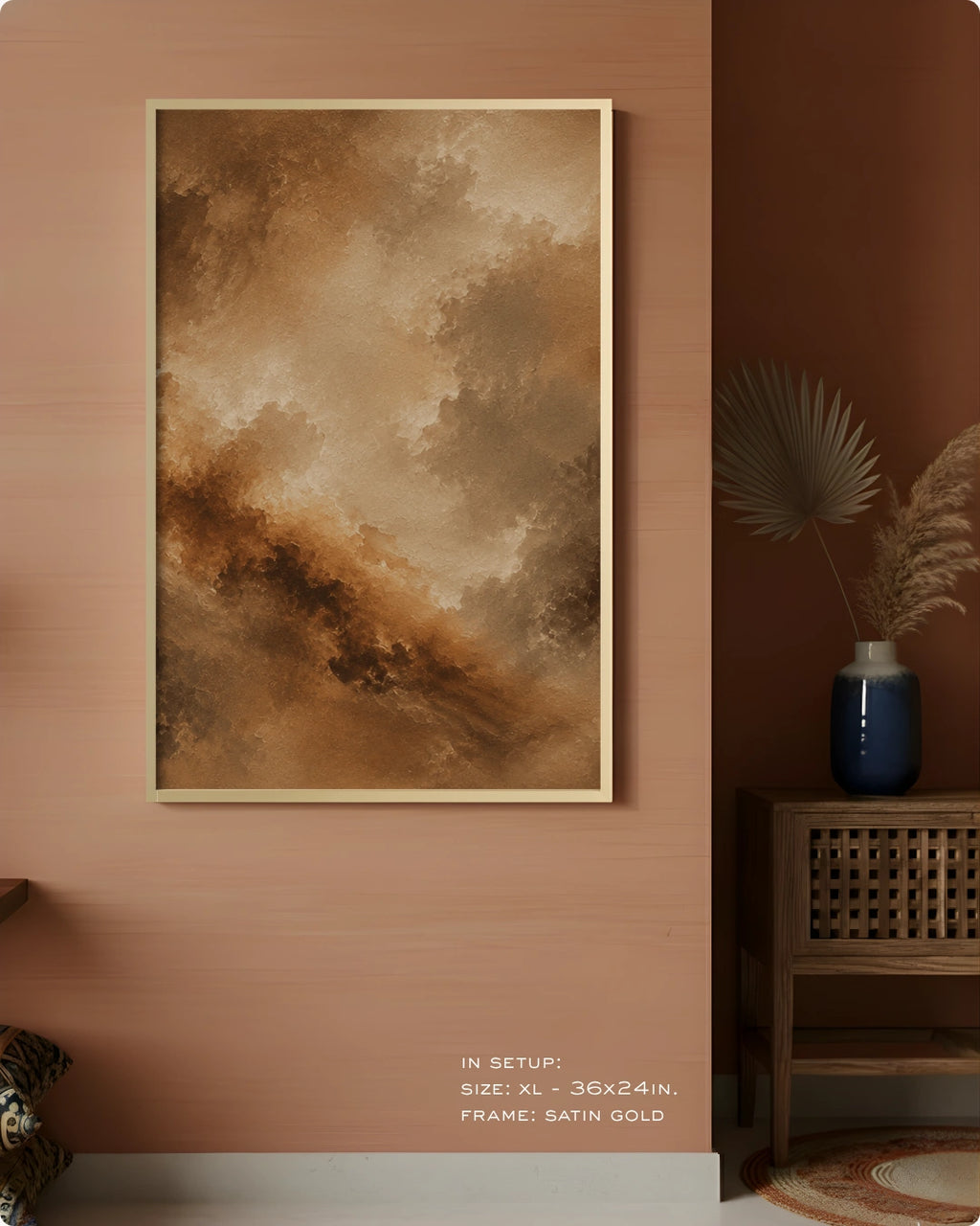 A framed abstract landscape art print featuring shades of brown, beige, and tan, displayed on a warm terracotta wall in a styled interior setting with a wooden side table and a blue ceramic vase.