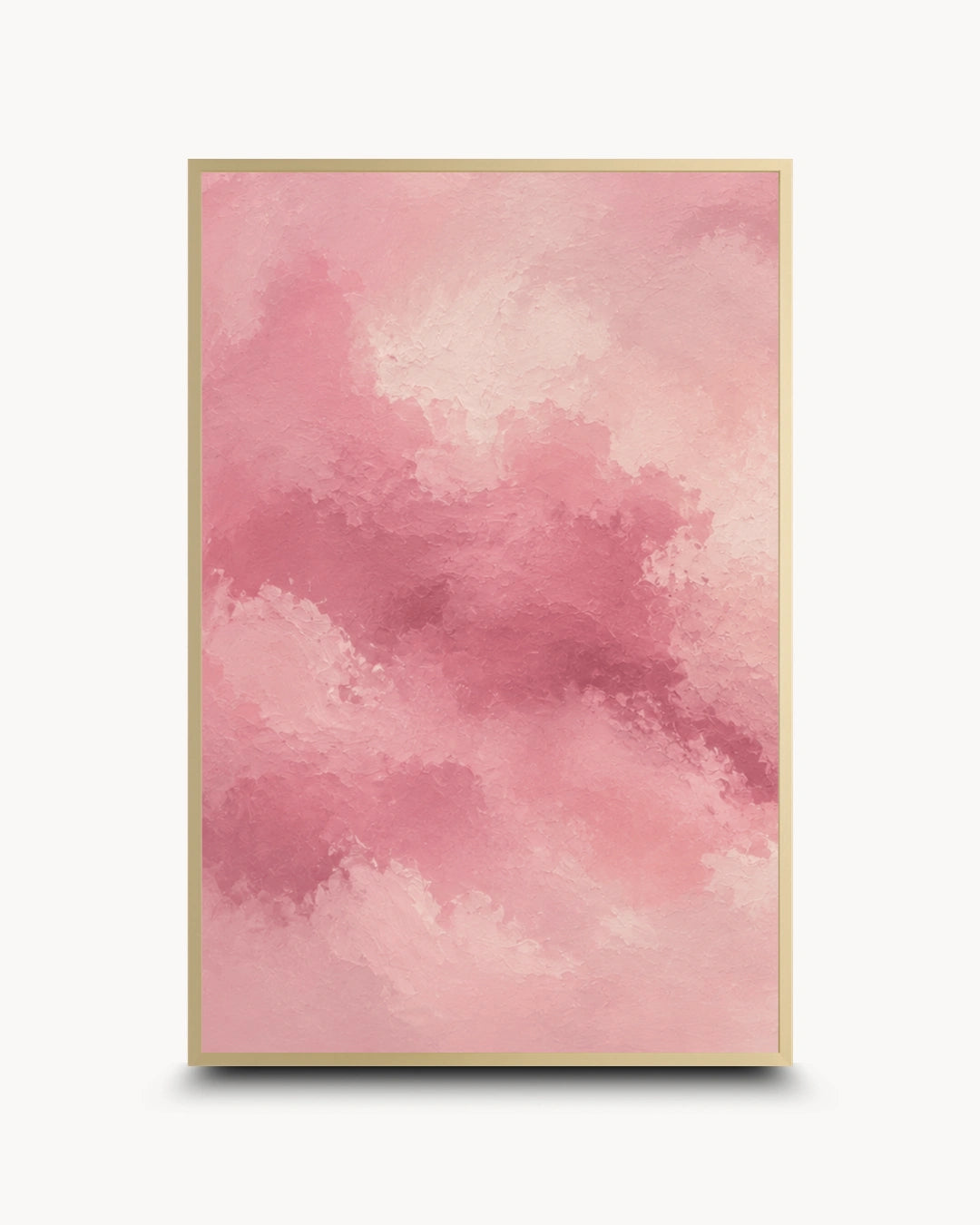 A vertical framed art print featuring an abstract watercolor-style pink cloud pattern, enclosed in a thin gold frame against a clean white background.