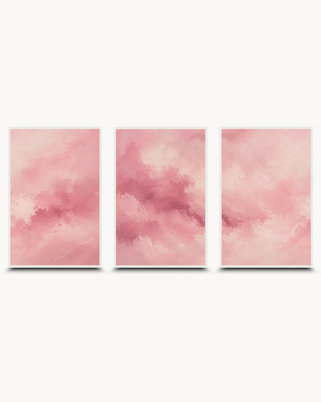 Three vertical framed wall art panels with soft pink watercolor-like abstract clouds, arranged side by side on a light gray background.