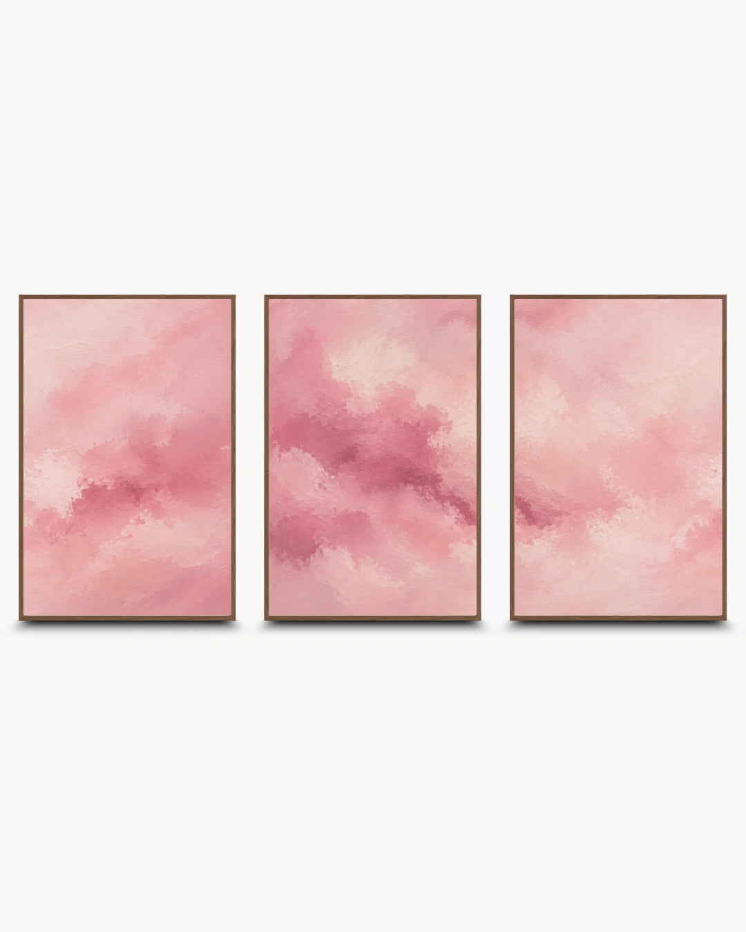 Three vertical framed wall art panels with soft pink watercolor-like abstract clouds, arranged side by side on a light gray background.