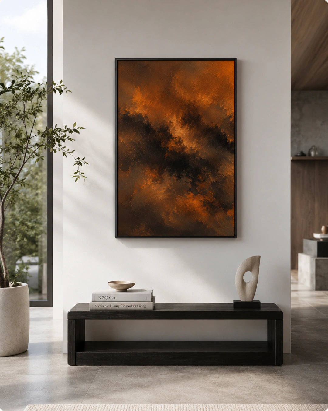 A framed abstract canvas print featuring a dramatic swirl of burnt orange, brown, and black paint, displayed on a white wall above a black console table in a modern, sunlit living room.