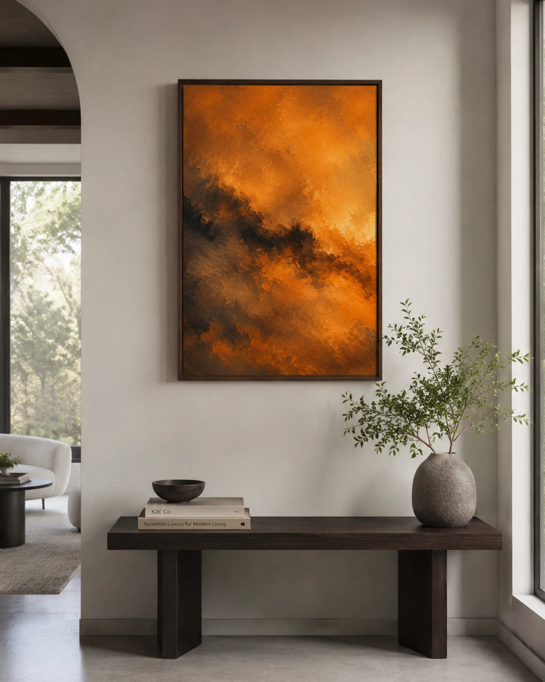A framed abstract painting with vibrant orange and dark brown cloud-like textures hangs on a light gray wall above a dark wooden bench in a modern living room setting.