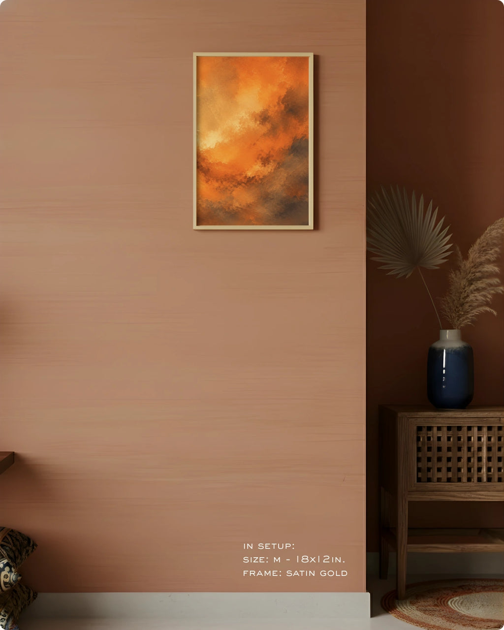 A framed abstract art print featuring vibrant orange and yellow clouds with dark brown undertones, hung on a textured terracotta wall in a styled interior setting.