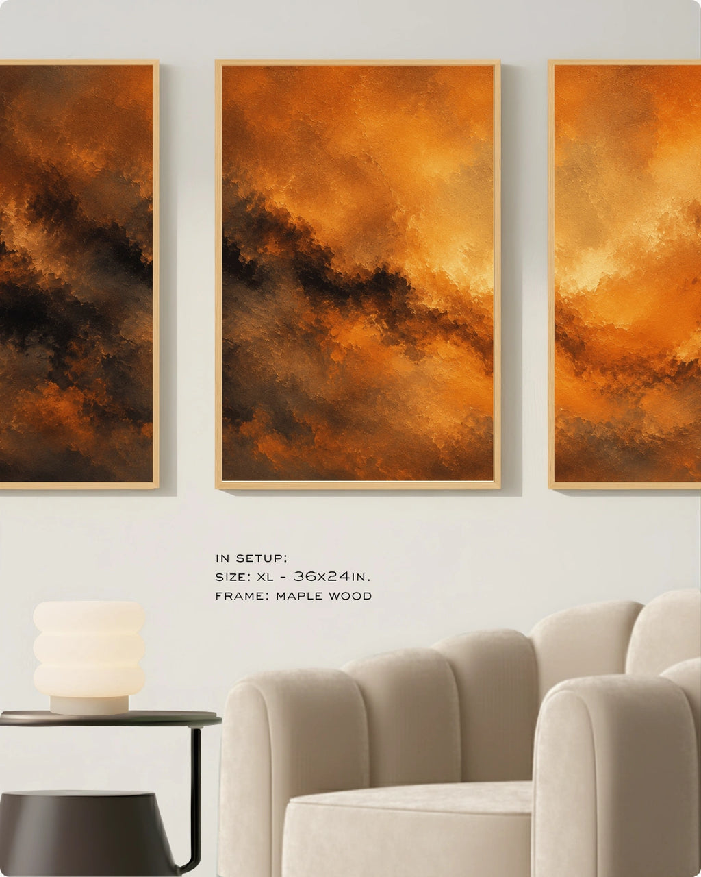 Three vertical framed abstract wall art panels in warm orange, gold, and brown tones, displayed above a light beige armchair in a styled interior setting. Text below reads: 'IN SETUP: XL - 36x24in.