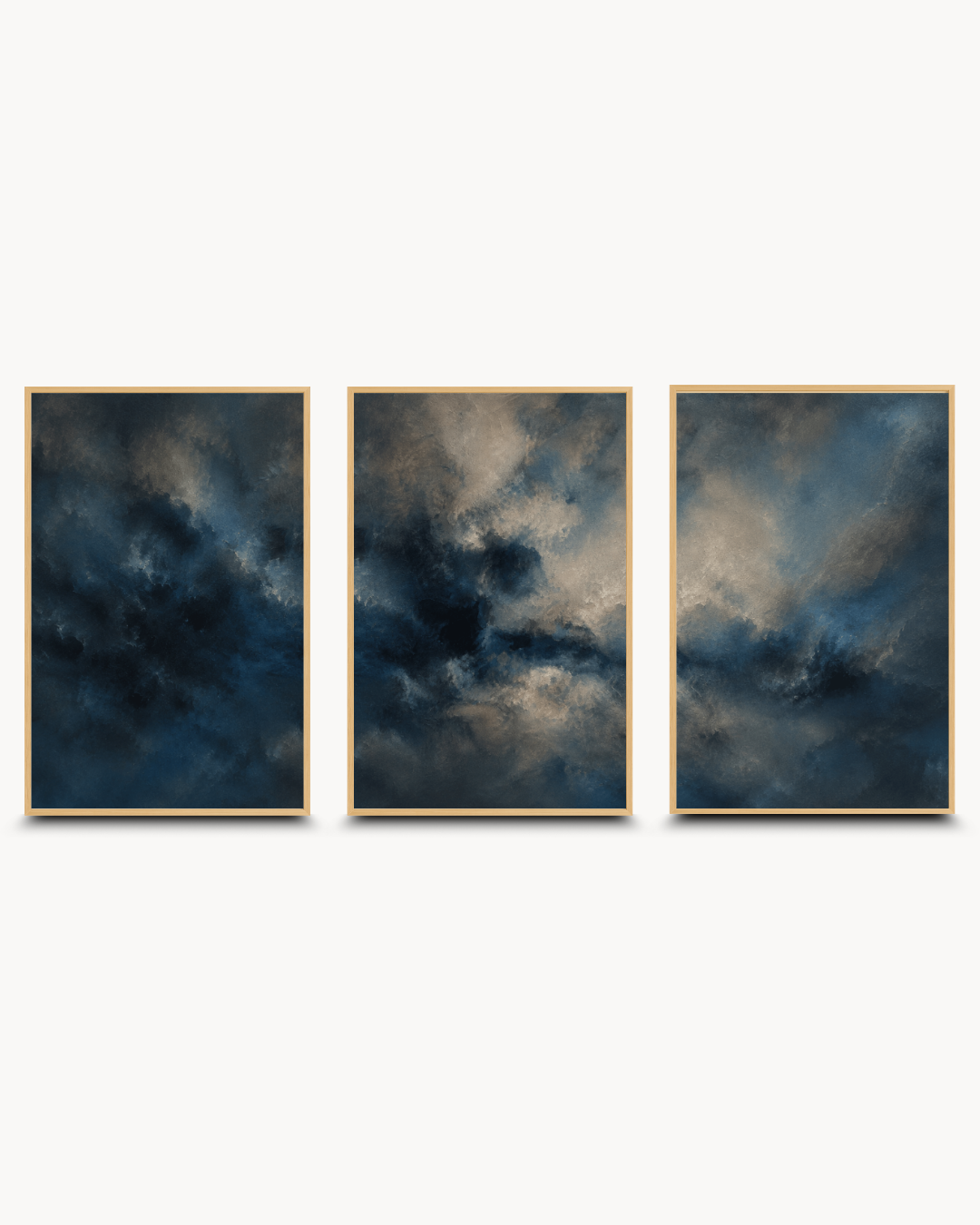 A three-panel framed wall art set featuring dramatic dark blue and gray cloudy abstract scenes, each in a thin gold frame, displayed against a light gray background.