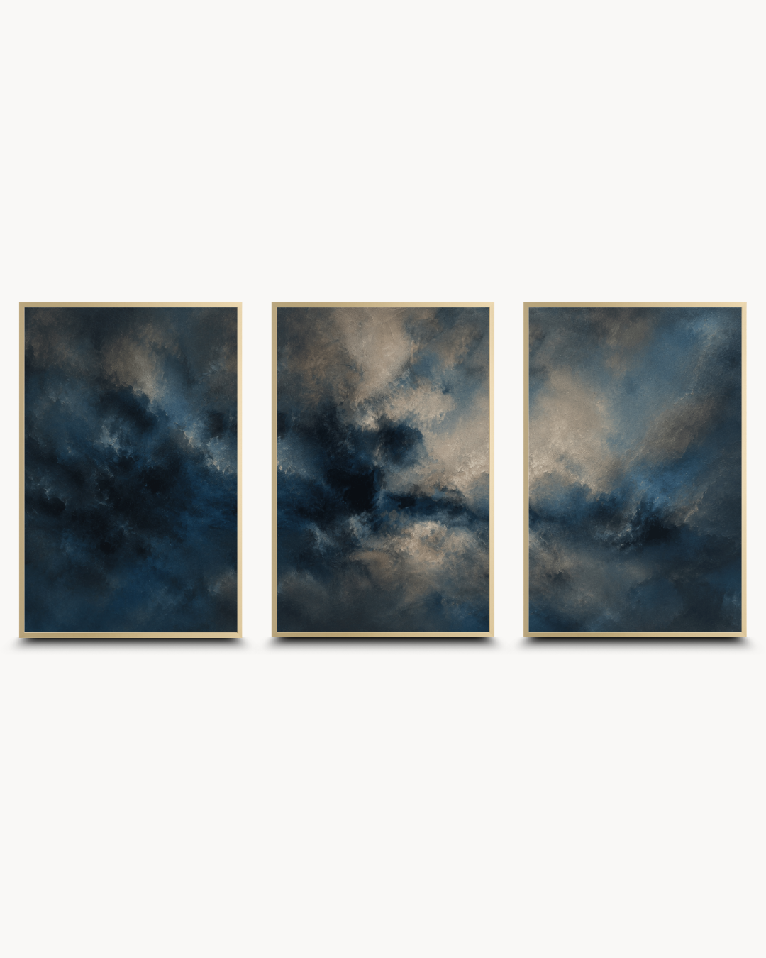 A three-panel framed wall art set featuring dramatic dark blue and gray cloudy abstract scenes with thin gold-toned frames, displayed against a light gray background.