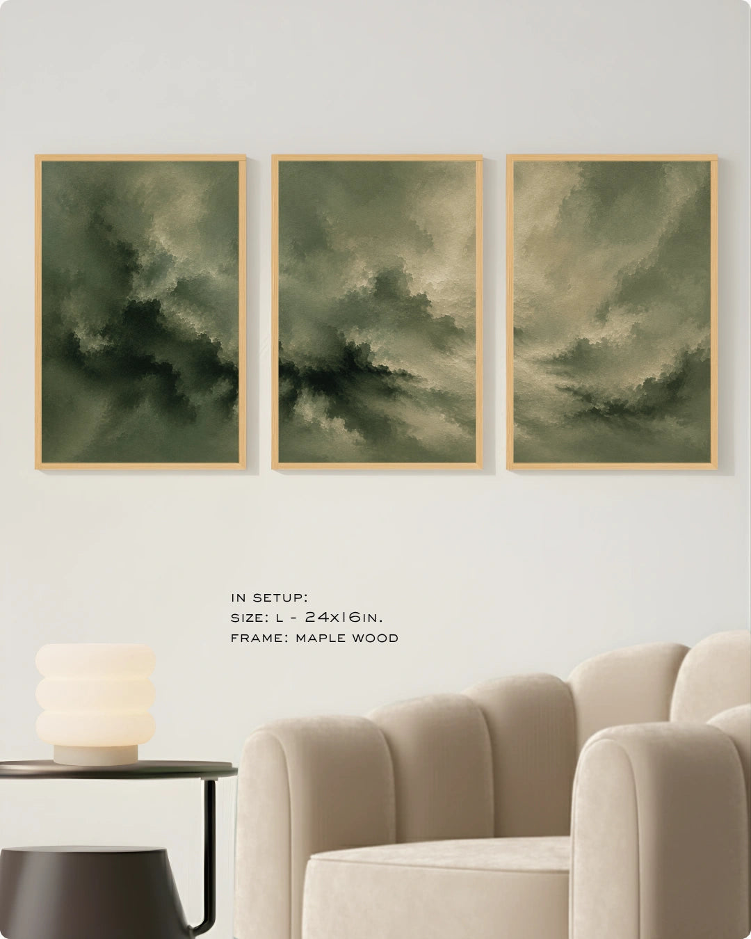 Three framed abstract wall art prints with dark green and gray storm-like clouds, displayed above a cream sofa in a styled interior. Small text reads 'IN SETUP: SIZE: L-24x16in.