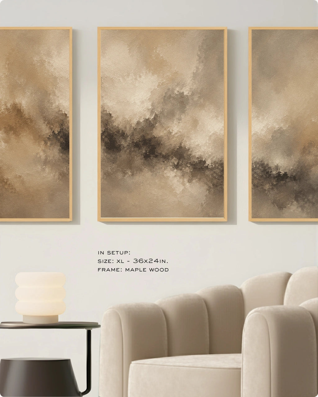 Three vertical framed abstract wall art panels in warm beige, taupe, and brown tones hang above a cream sofa in a styled interior. Small text below reads: 'IN SETUP: XL - 36x24in.