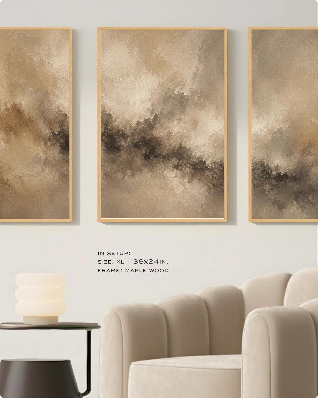 Three vertical framed abstract wall art panels in warm beige, taupe, and brown tones hang above a cream sofa in a styled interior. Small text below reads: 'IN SETUP: XL - 36x24in.