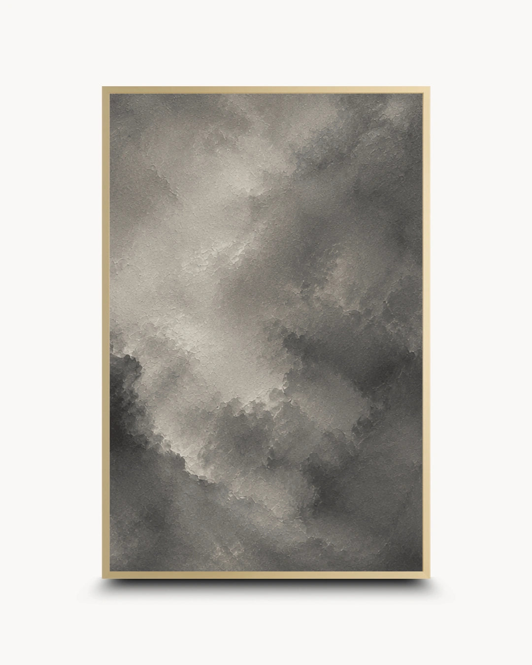 A framed abstract art print featuring a textured, painterly cloud-like pattern in shades of gray and black, enclosed in a thin gold frame against a clean white background.