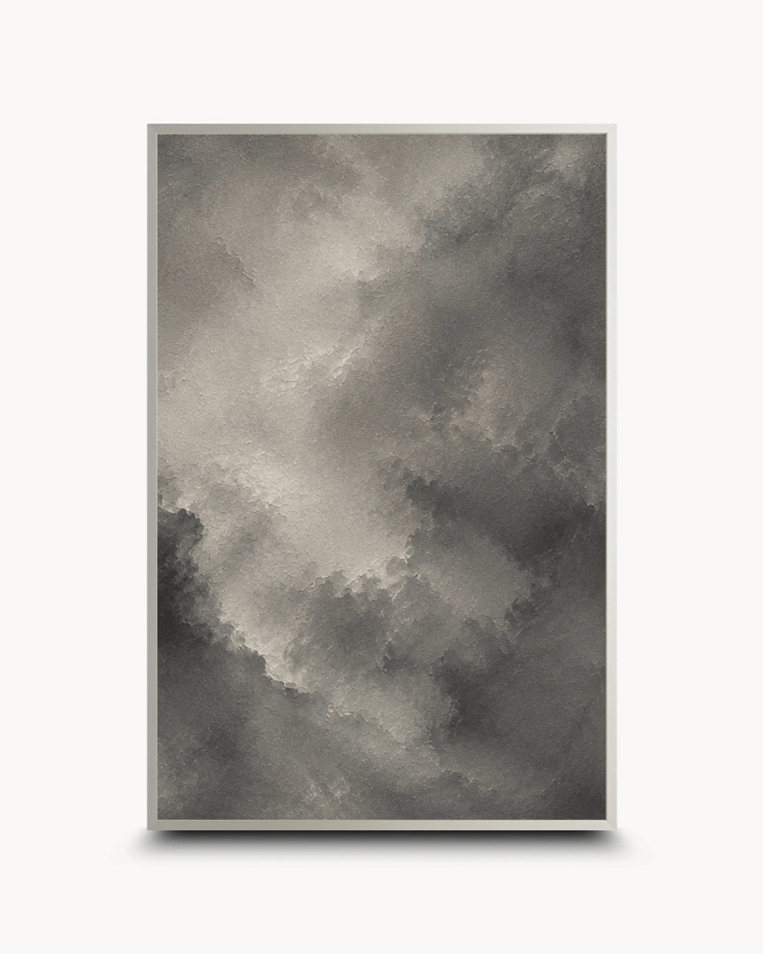 A framed abstract art print featuring a textured, painterly cloud-like composition in shades of gray, charcoal, and off-white, set against a clean white background.