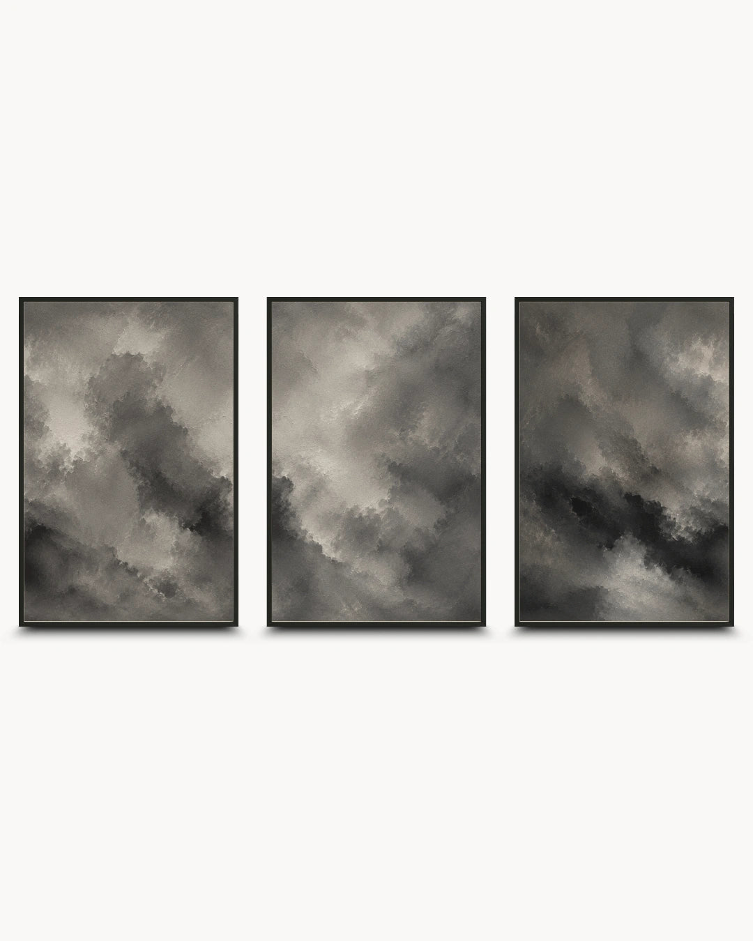 Three framed vertical wall art prints with dark gray and black cloudy abstract designs, arranged side by side on a light gray background.