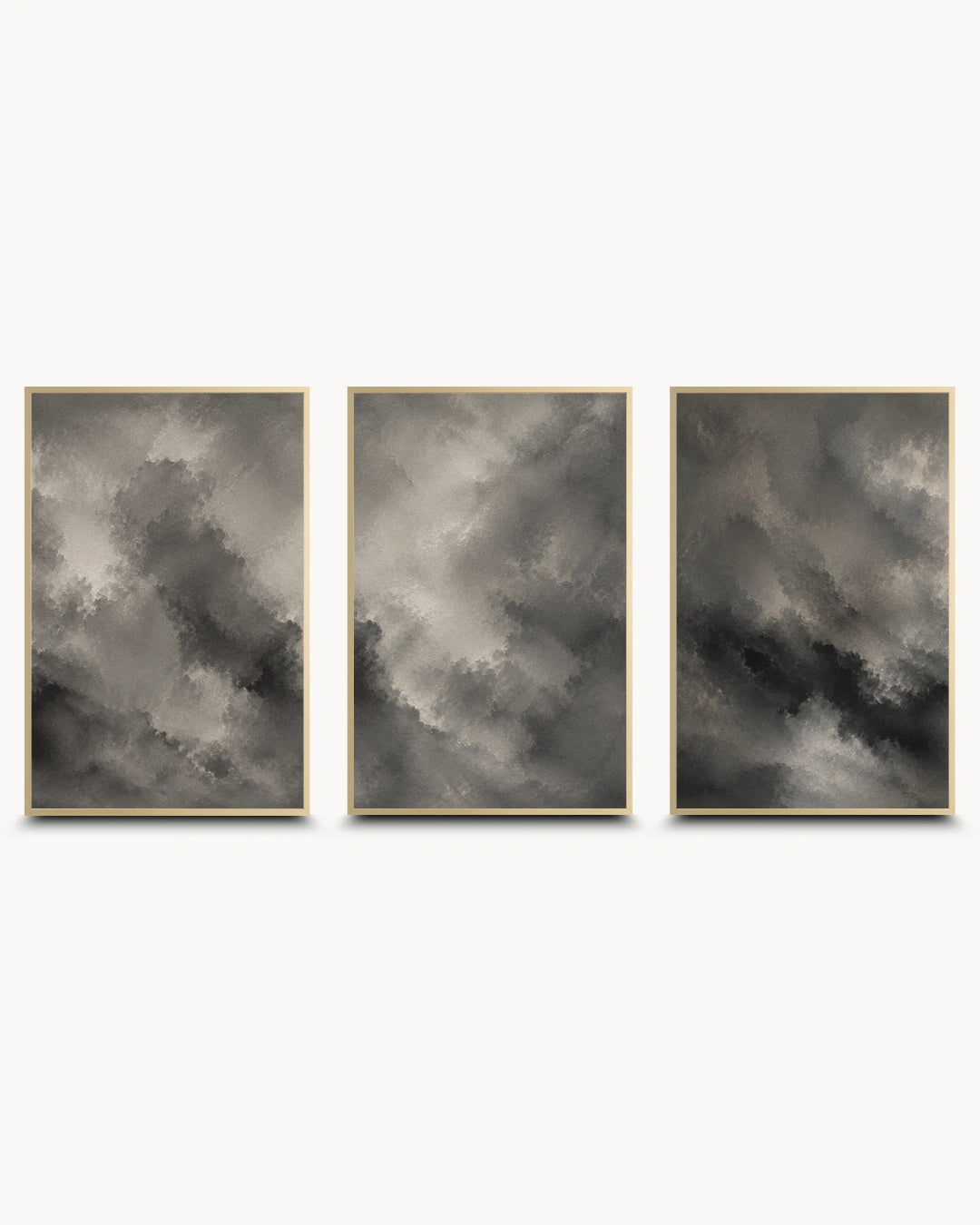 A three-piece framed wall art set featuring abstract gray and black cloud-like paintings with thin gold frames, displayed side by side on a light gray background.