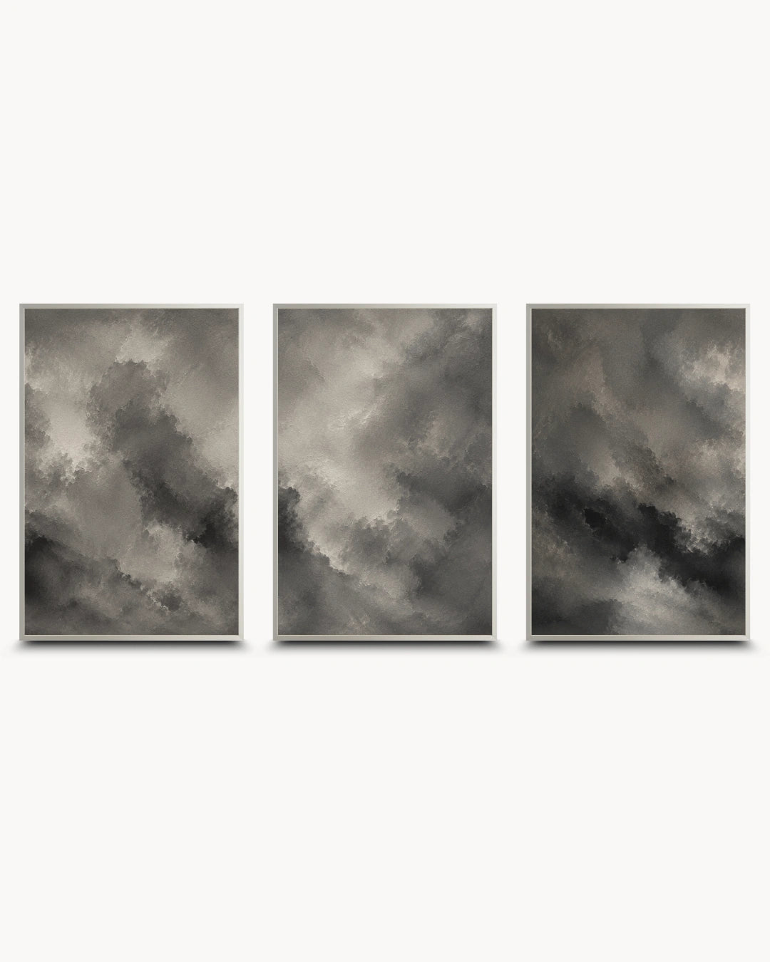 A three-piece framed wall art set featuring abstract gray and black cloud-like paintings with thin gold frames, displayed side by side on a light gray background.