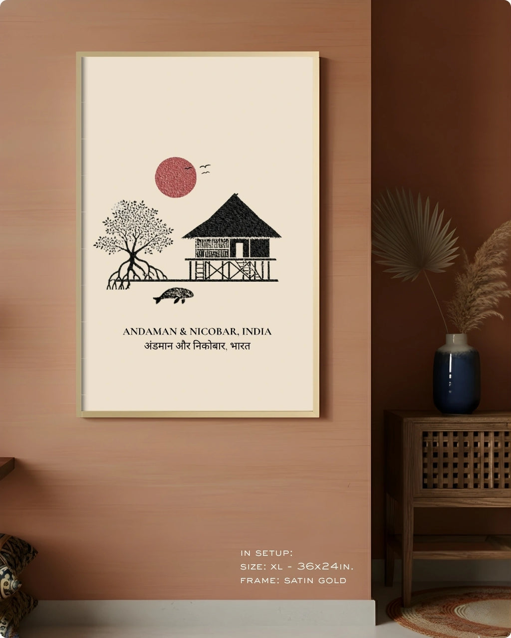 A framed wall art print hangs on a terracotta-colored wall in a styled interior. The print features a minimalist black line drawing of a house, tree, and turtle with a red sun, plus the text 'ANDAMAN & NICOBAR, INDIA' and Devanagari text.