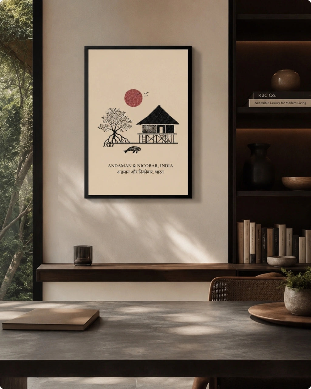 A framed minimalist art print hangs on a beige wall in a modern interior setting. The print features a black line drawing of a house and tree with a red sun and the text 'ANDAMAN & NICOBAR INDIA' below.