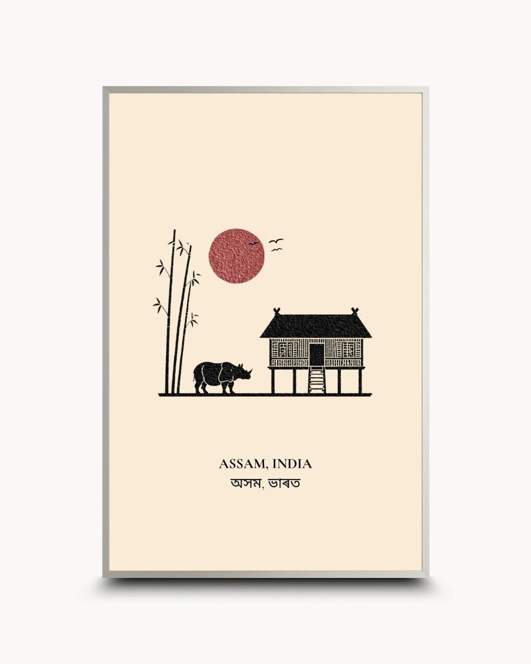 A minimalist art print poster featuring a black silhouette illustration of a house, a rhinoceros, bamboo, and a red sun on a cream background, with the text 'ASSAM, INDIA' and Bengali script below. The poster is shown with a thin gray frame against a light gray background.