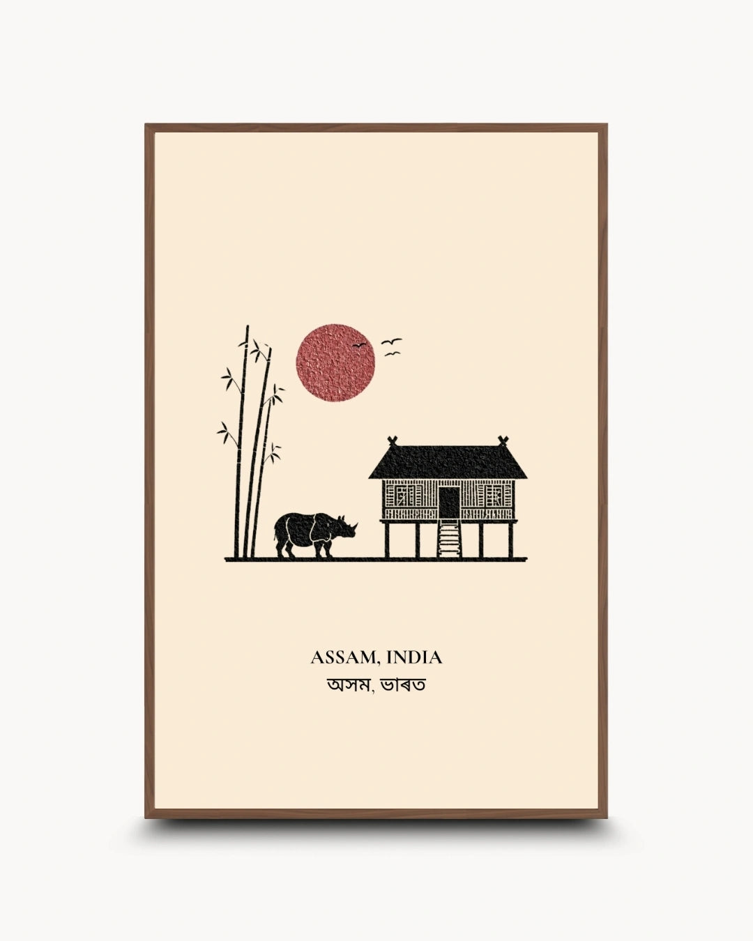 A framed art print featuring a minimalist illustration of Assam, India, with a stilt house, rhinoceros, bamboo, birds, and a red sun on a cream background, with the text 'ASSAM, INDIA' and Bengali script below.