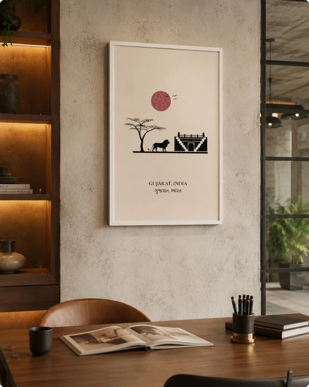 A framed art print featuring a minimalist black and red illustration of a Gujarat landscape with a tree, camel, and mosque, displayed on a textured beige wall in a modern, warmly lit interior setting.