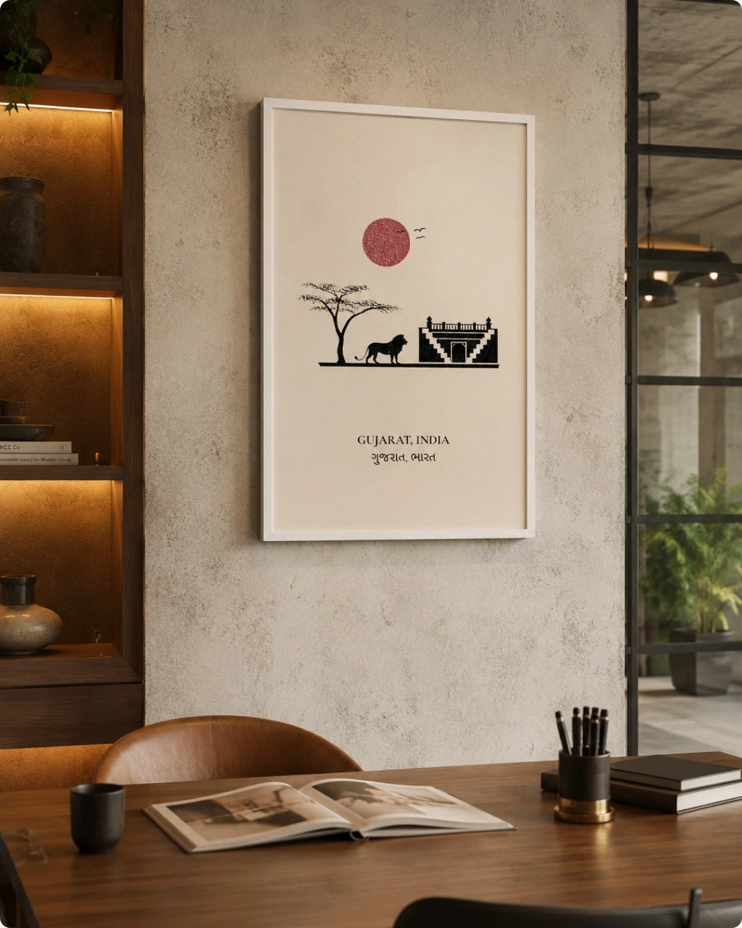 A framed art print featuring a minimalist black and red illustration of a Gujarat landscape with a tree, camel, and mosque, displayed on a textured beige wall in a modern, warmly lit interior setting.