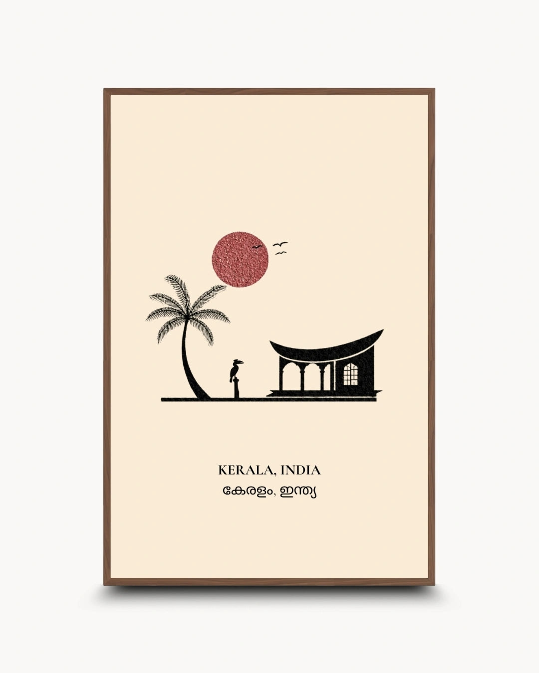 A vertical framed art print featuring a minimalist illustration of Kerala, India. The print has a cream background with a black silhouette of a palm tree, a traditional house, and a person, alongside a dusty red sun and the text 'KERALA, INDIA' with Malayalam script below.