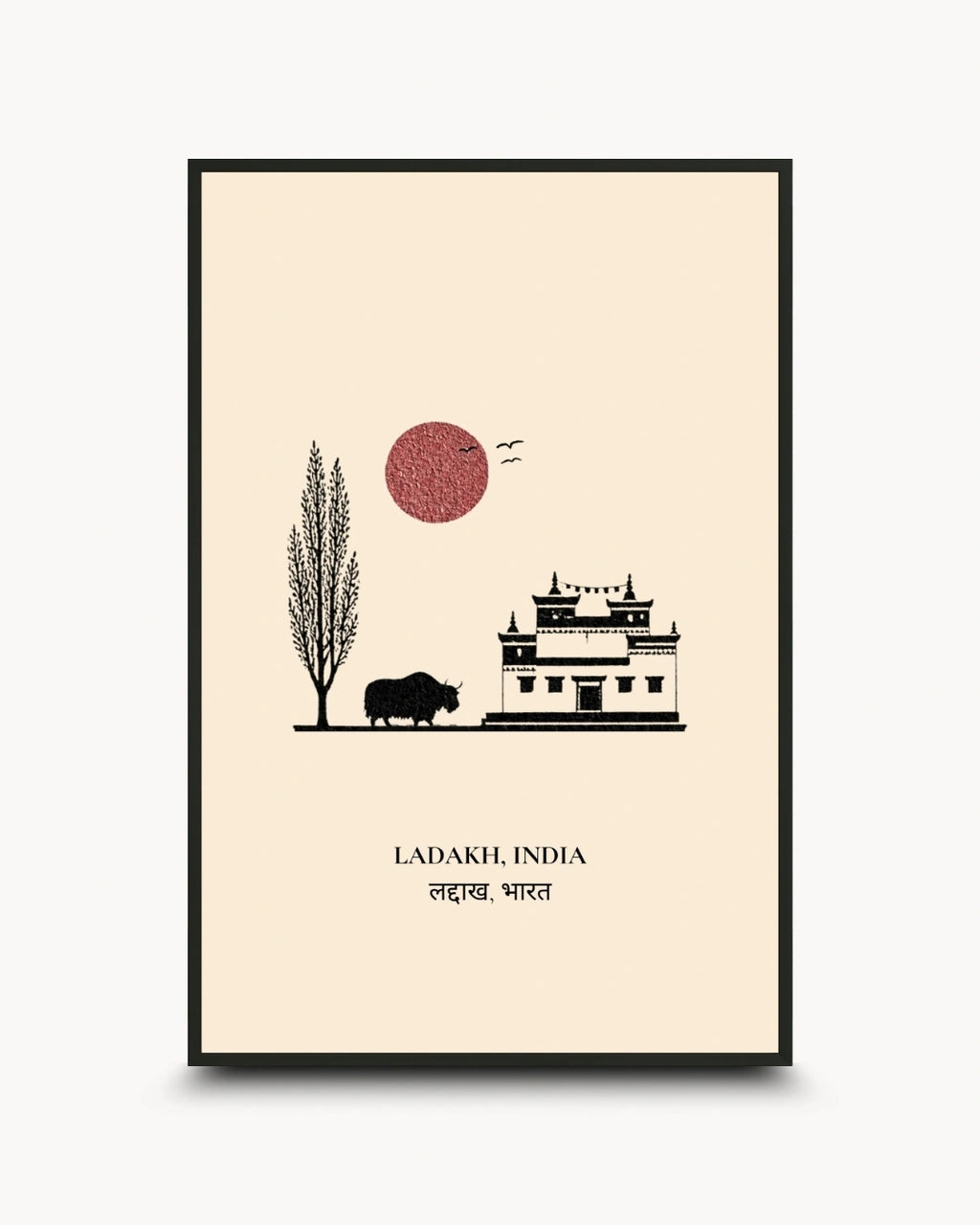 A framed travel art print of Ladakh, India, featuring a minimalist black line drawing of a building, a tree, a bison, and a red sun on a cream background, enclosed in a thin black frame.