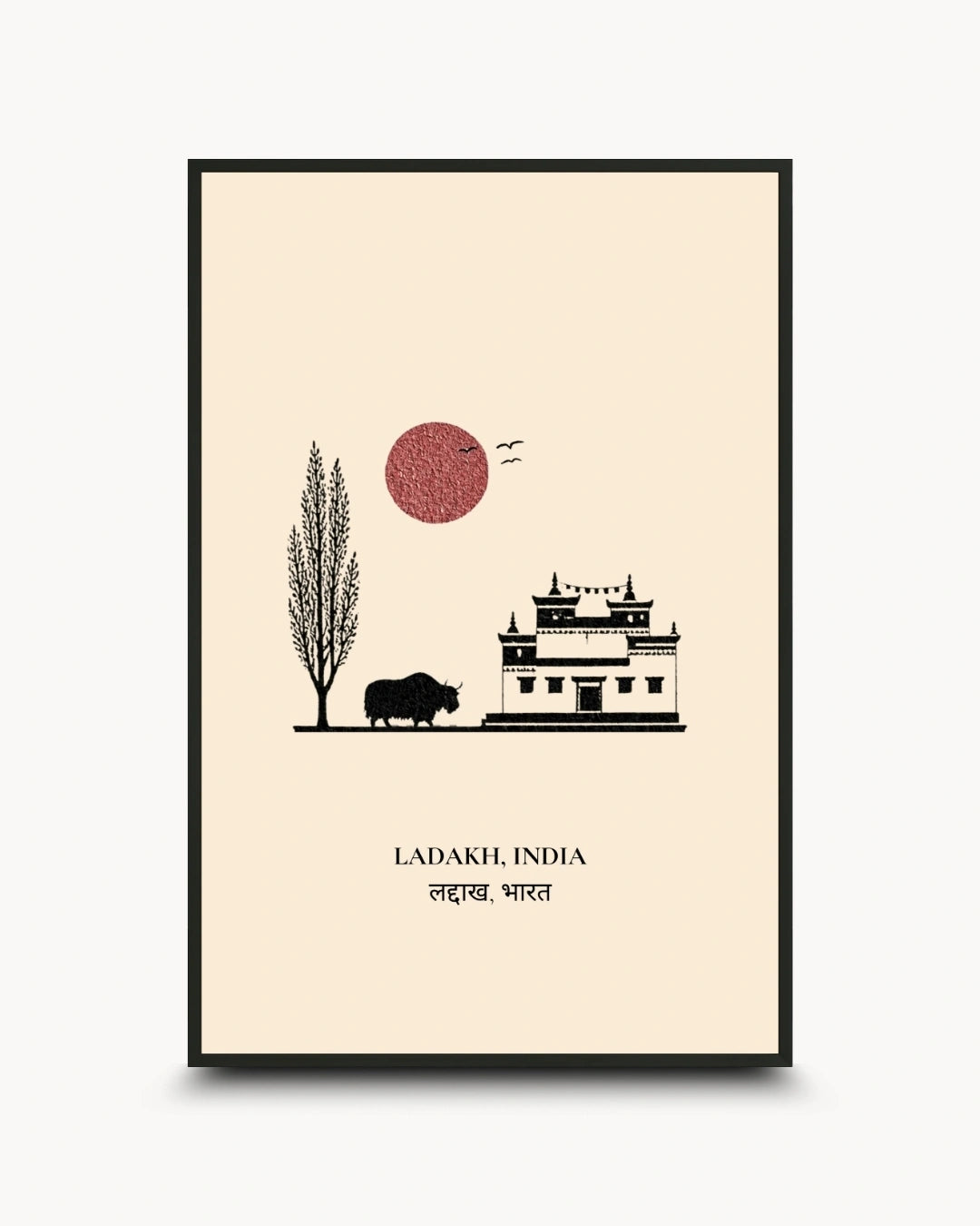A framed travel art print of Ladakh, India, featuring a minimalist black line drawing of a building, a tree, a bison, and a red sun on a cream background, enclosed in a thin black frame.