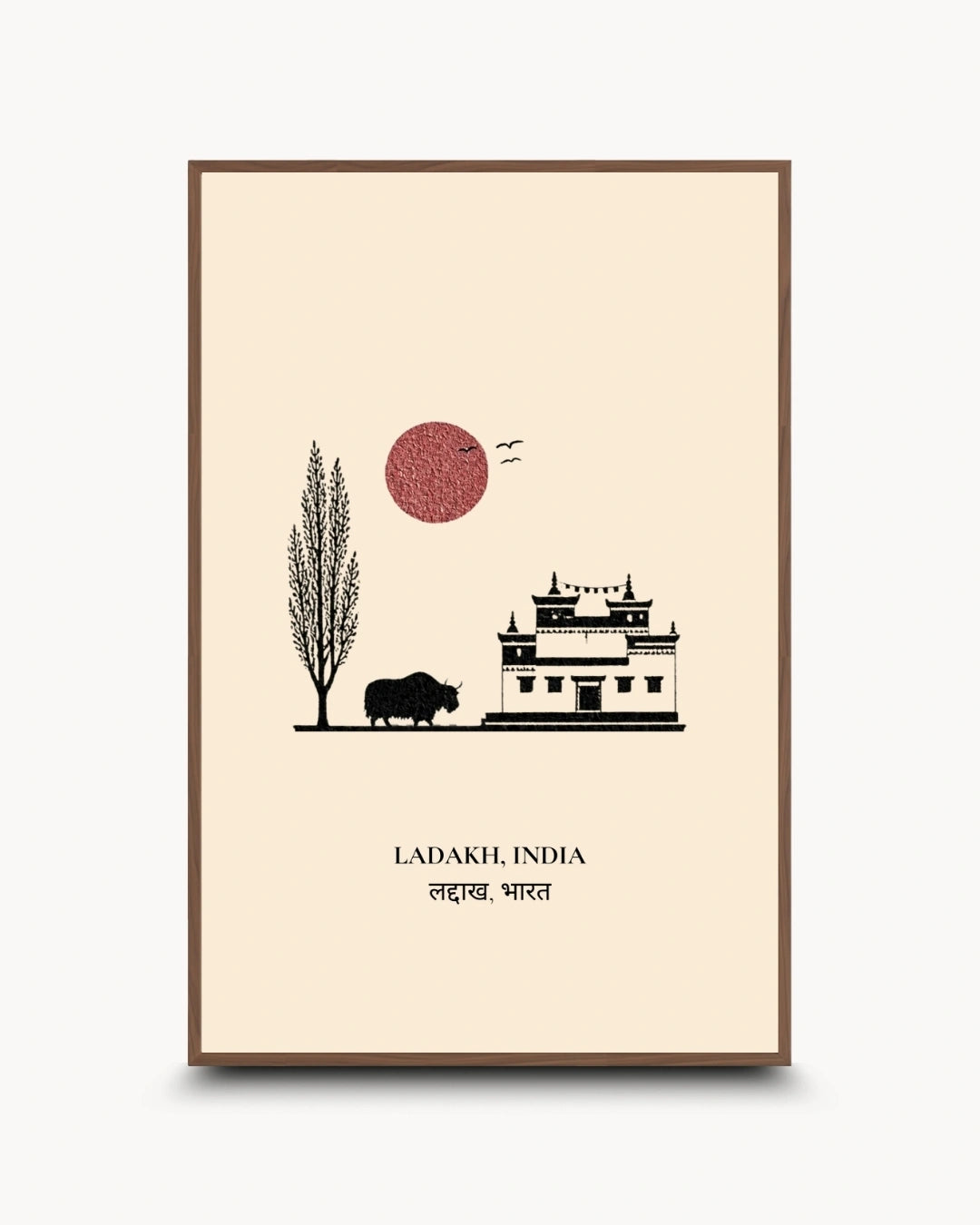 A vertical travel art print of Ladakh, India, featuring a minimalist black line drawing of a building, a tree, and a bison under a textured red sun, framed in brown on a cream background.
