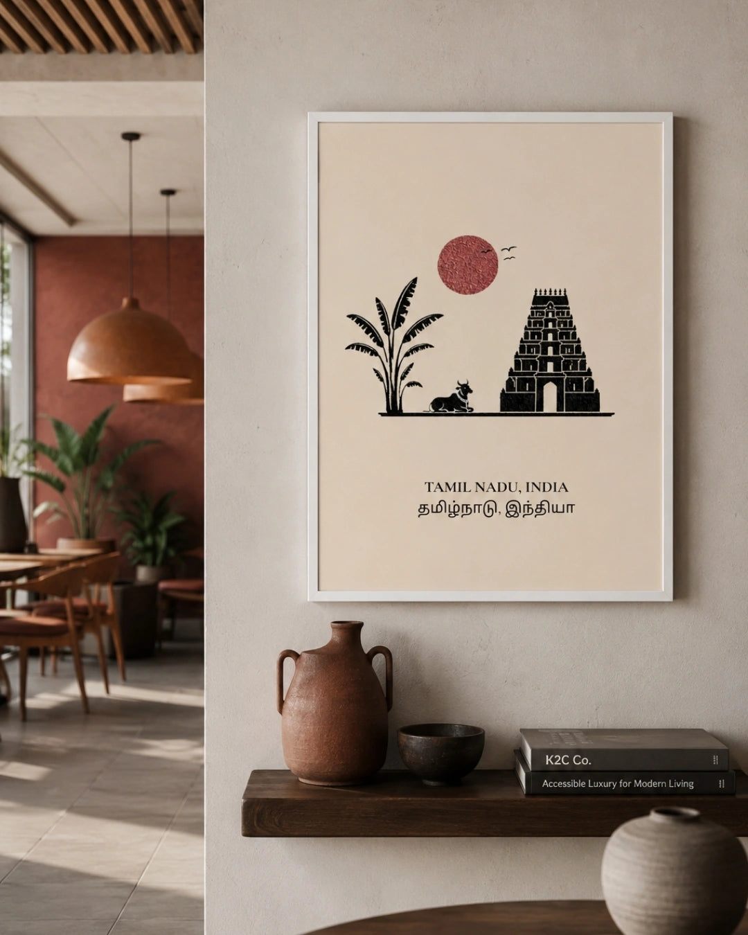 A framed minimalist art print of Tamil Nadu, India, hanging on a beige wall in a modern, warm-toned interior setting with a wooden shelf and decorative ceramic vessels below.