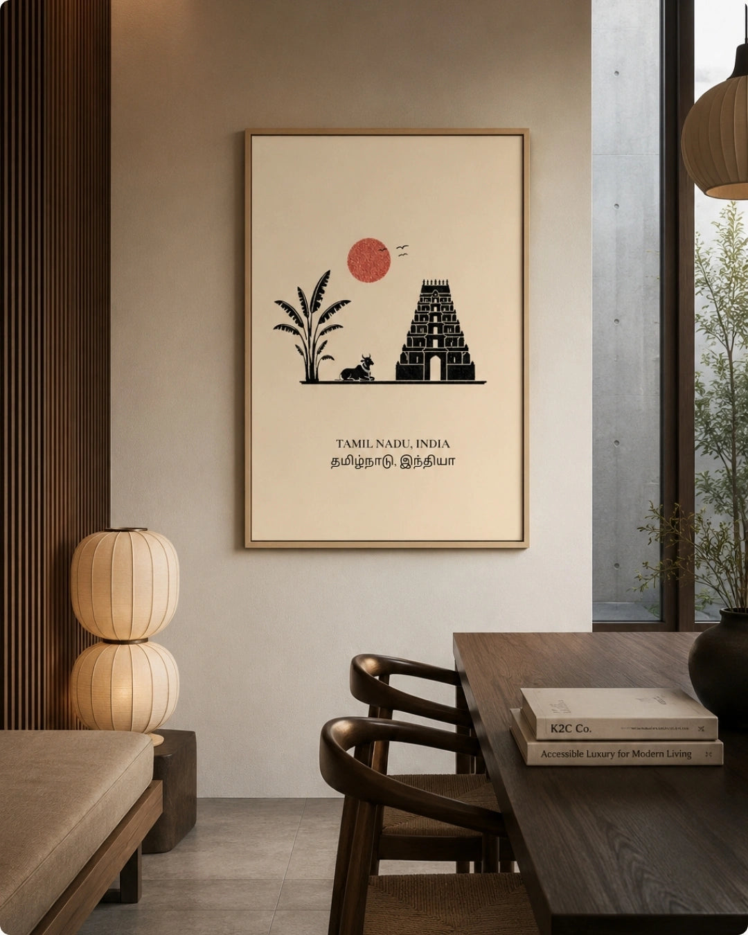 A framed minimalist Tamil Nadu art print hangs on a beige wall in a modern, warm-toned dining room setting with a wooden table, chairs, and a window.