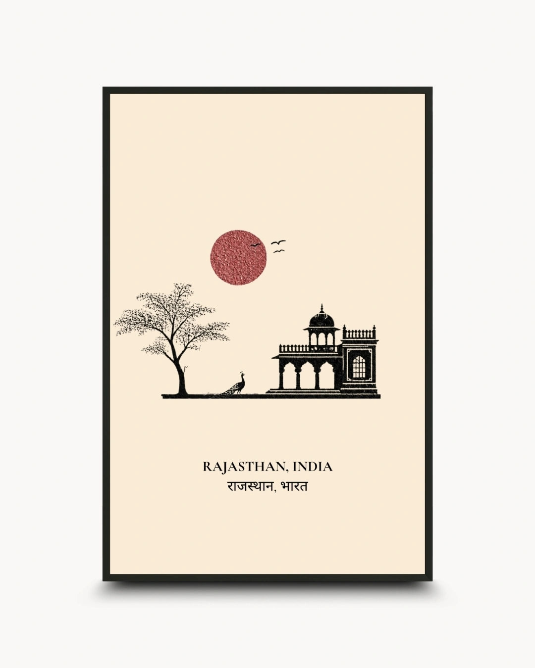 A framed travel art print of Rajasthan, India, featuring a minimalist black line drawing of a palace, a tree, and a red sun on a cream background, enclosed in a black frame.