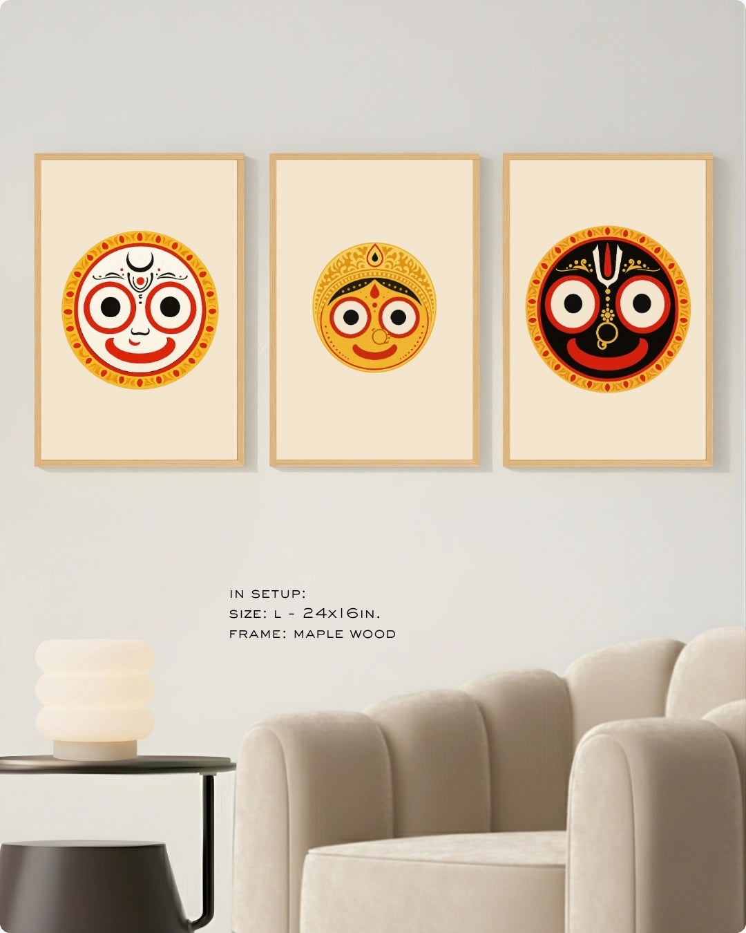Visual size guide mockup for the Jagannath Triad 3-piece wall art set in Large size with satin gold frames, displayed above a modern ribbed beige armchair.