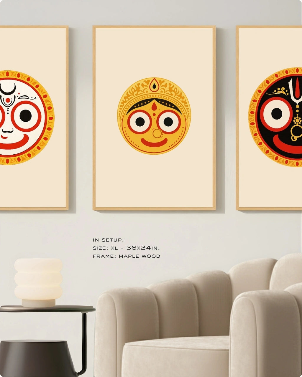 Visual size guide mockup for the Jagannath Triad 3-piece wall art set in Extra Large size with satin gold frames, displayed above a modern ribbed beige armchair.