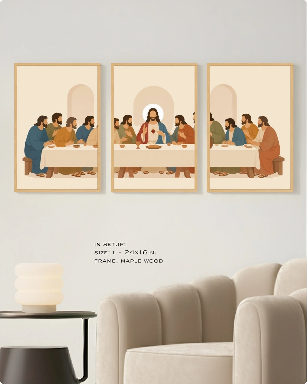 Three framed wall art prints depicting a stylized religious scene with figures seated around a table, shown mounted on a light wall above a sofa. The center print is slightly offset, and small text below reads 'IN SETUP: SIZE: L- 24x16in.