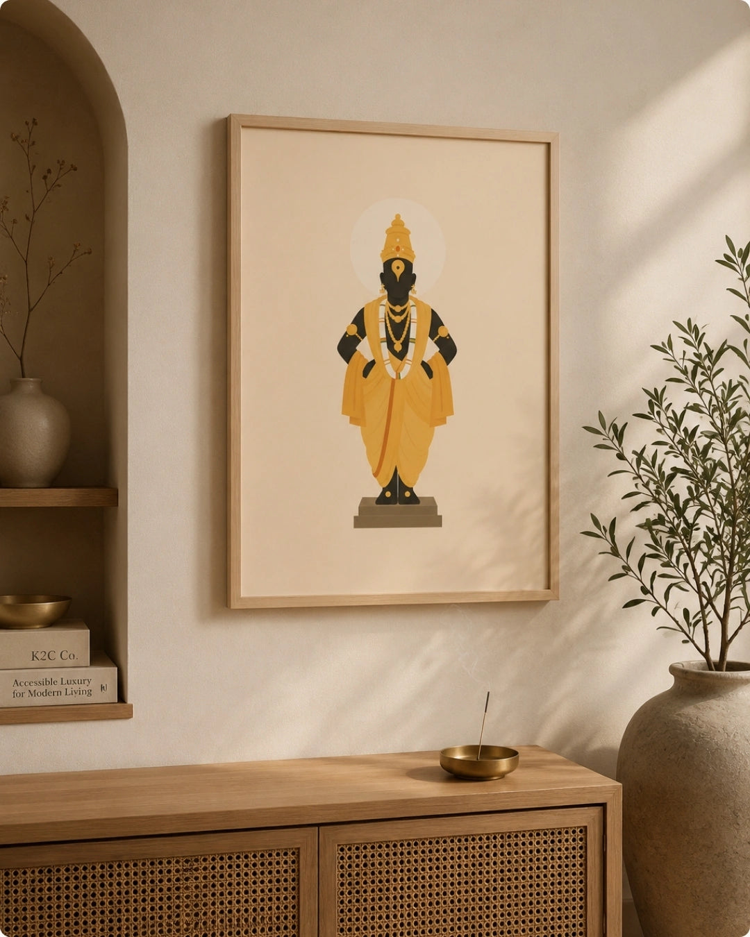 Lifestyle mockup of the Lord Vitthal wall art in a light maple wood frame displayed next to a decorative arched niche over a woven rattan cabinet.