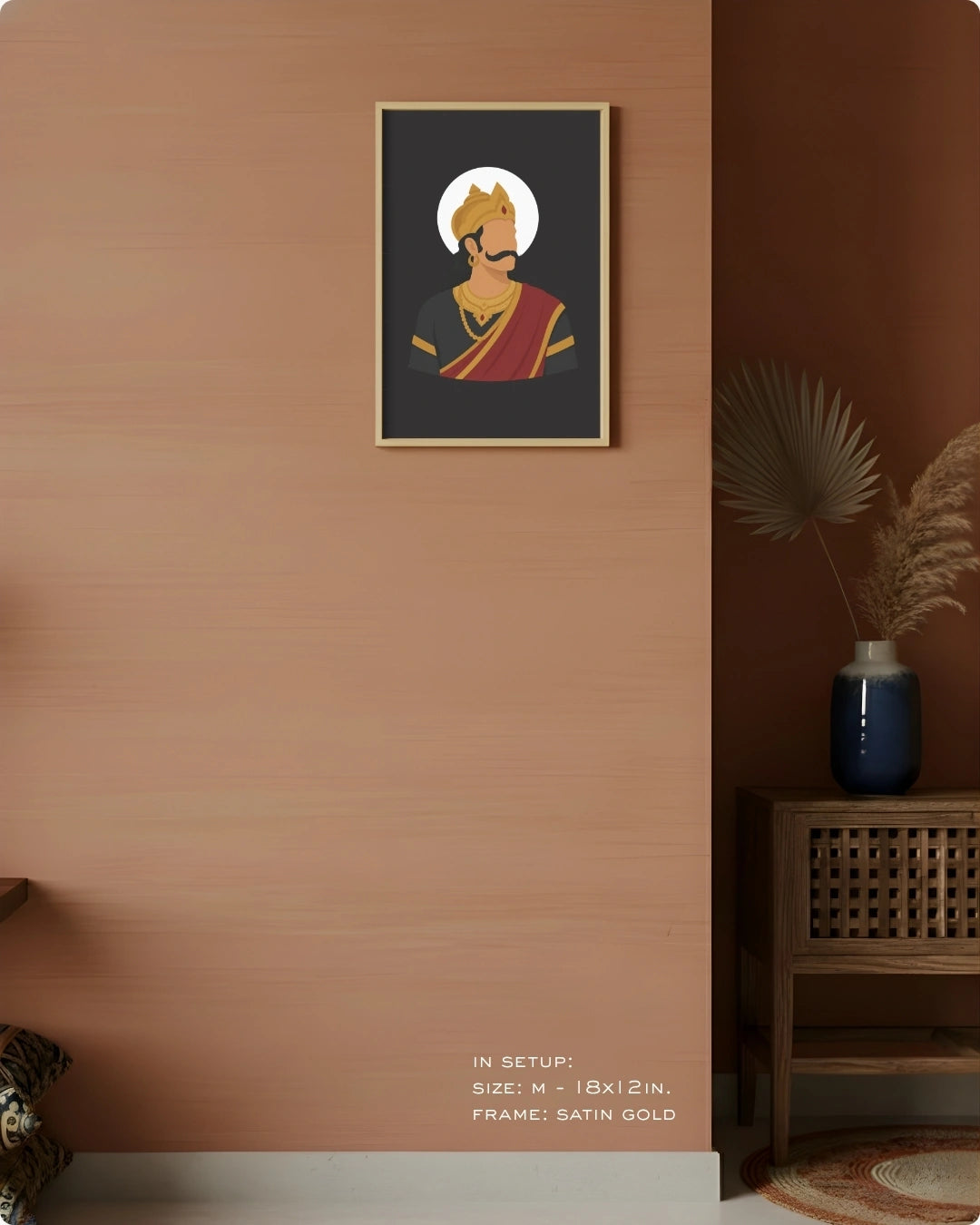 A framed art print featuring a stylized illustration of Raavana in a gold and red dhoti, displayed on a warm terracotta-colored wall in a styled interior setting.