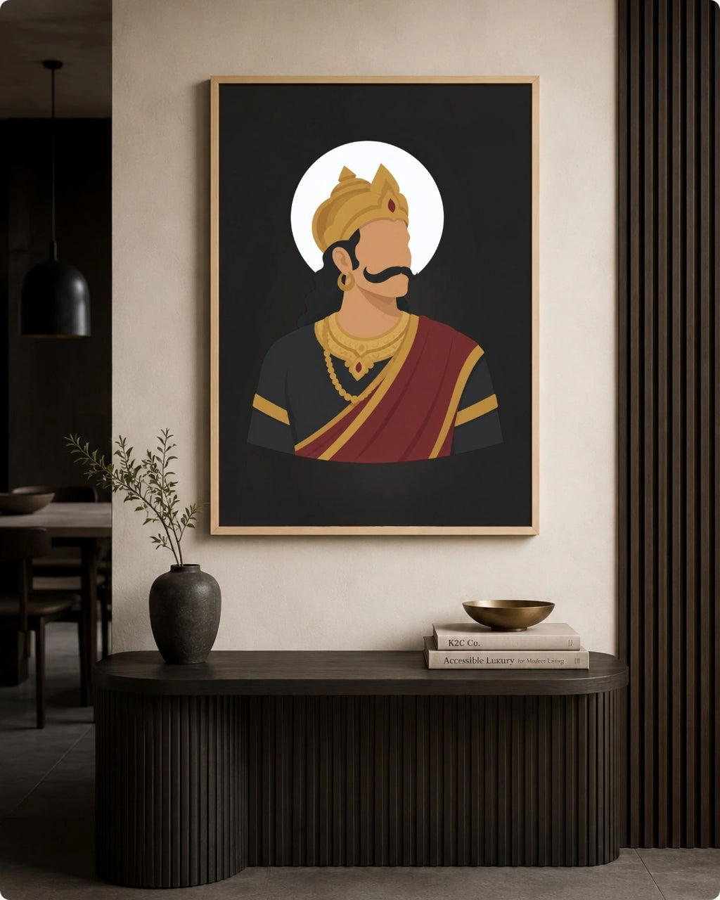 A framed art print featuring a stylized illustration of Raavana in traditional Indian attire, displayed on a beige wall above a dark wooden console table in a modern interior setting.