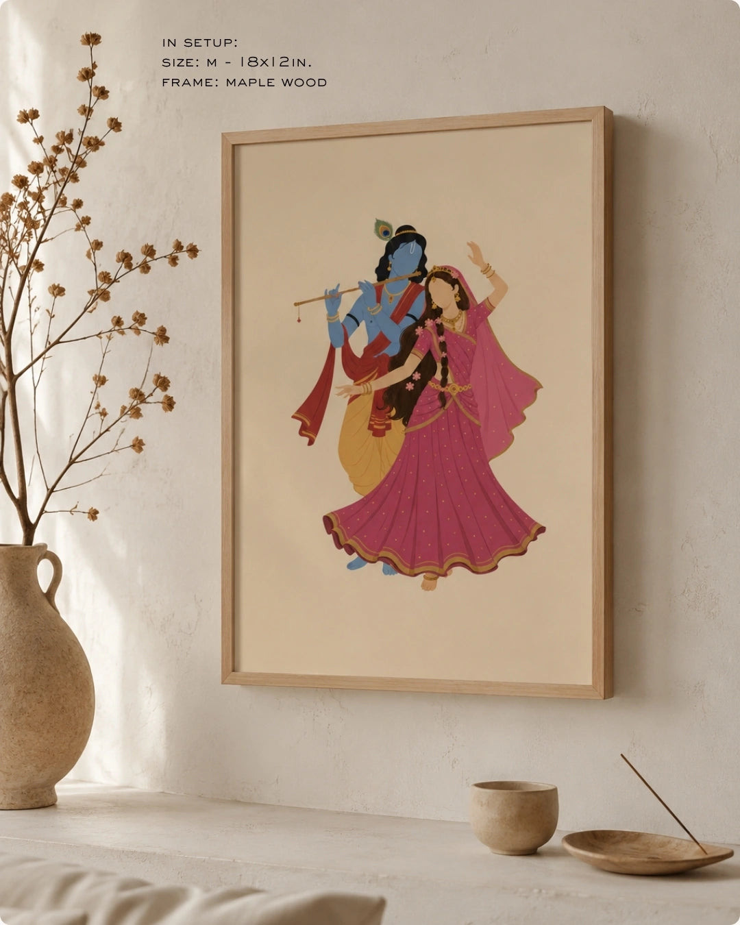 Lifestyle interior mockup of the Hindu divine couple Radha and Krishna wall art with a maple wood frame, paired with wabi-sabi elements like dry botanical branches and ceramic vases.