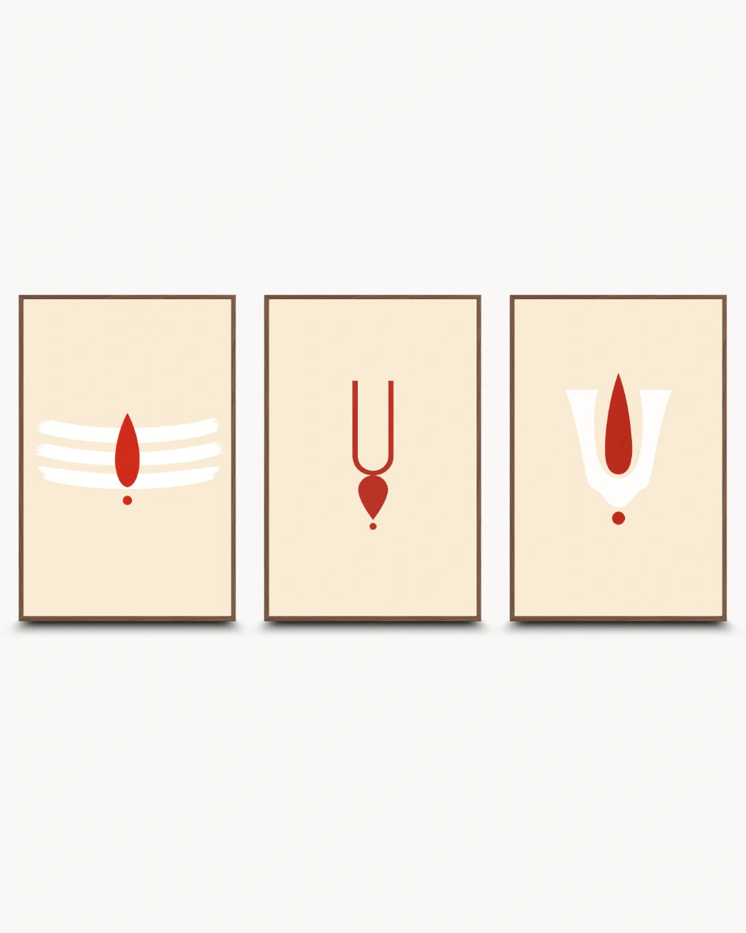 Three minimalist framed wall art prints with brown frames, displayed side by side on a light gray background. Each print has a cream background with a red and white spiritual symbol: a Shiva trishul on the left, a Yantra symbol in the center, and a Shiva Prabhavali on the right.