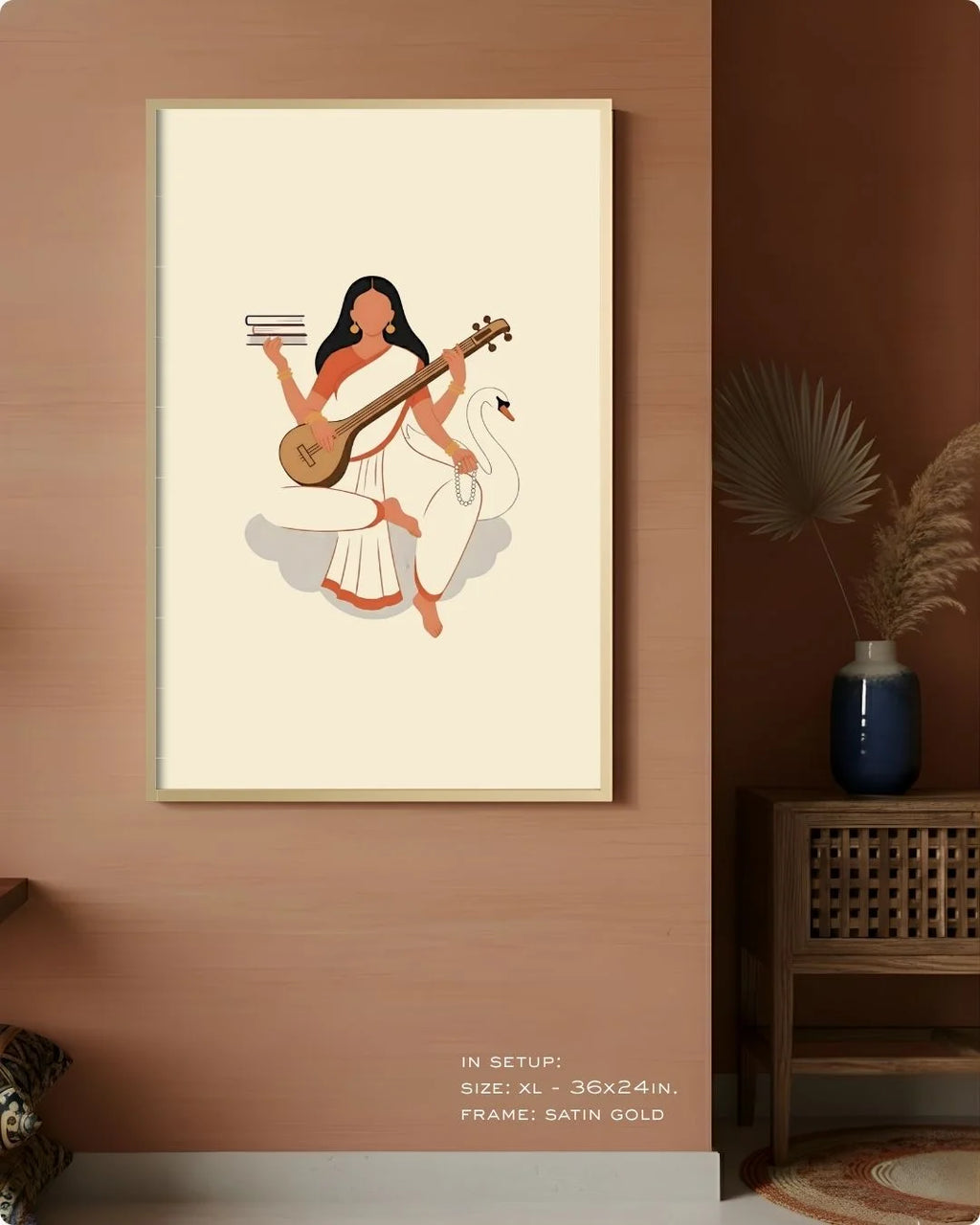 Large (Size L - 24x16in) Saraswati divine print in a Satin Gold frame, styled on a warm terracotta wall for a modern spiritual aesthetic.
