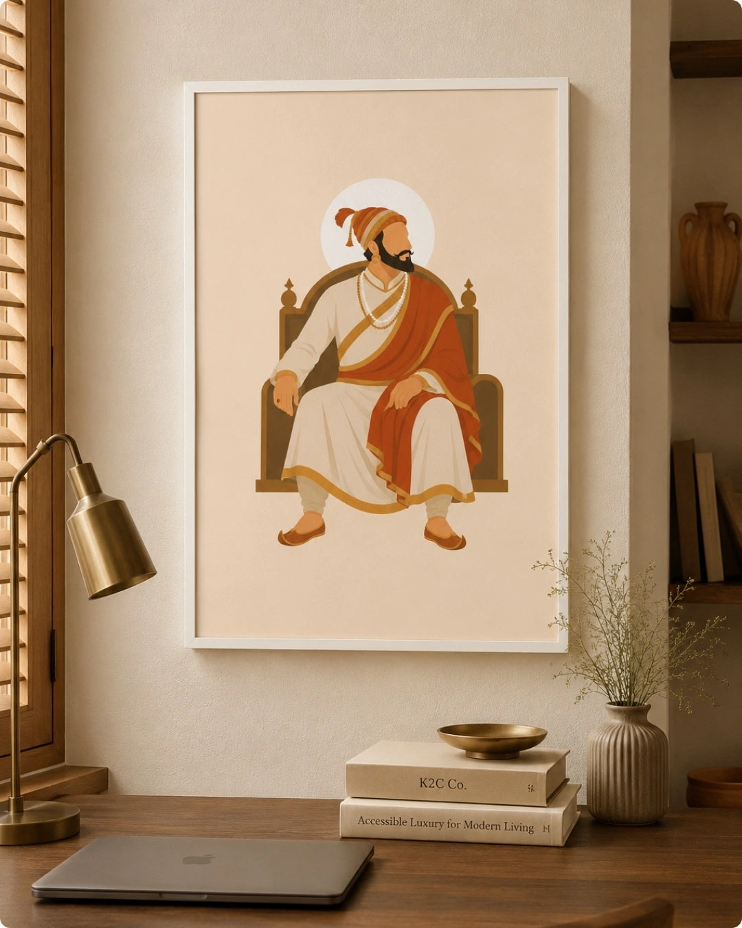 Lifestyle interior mockup of the seated Shivaji Maharaj wall art in a clean white frame hung over a modern study desk next to a desk lamp and stacked books.
