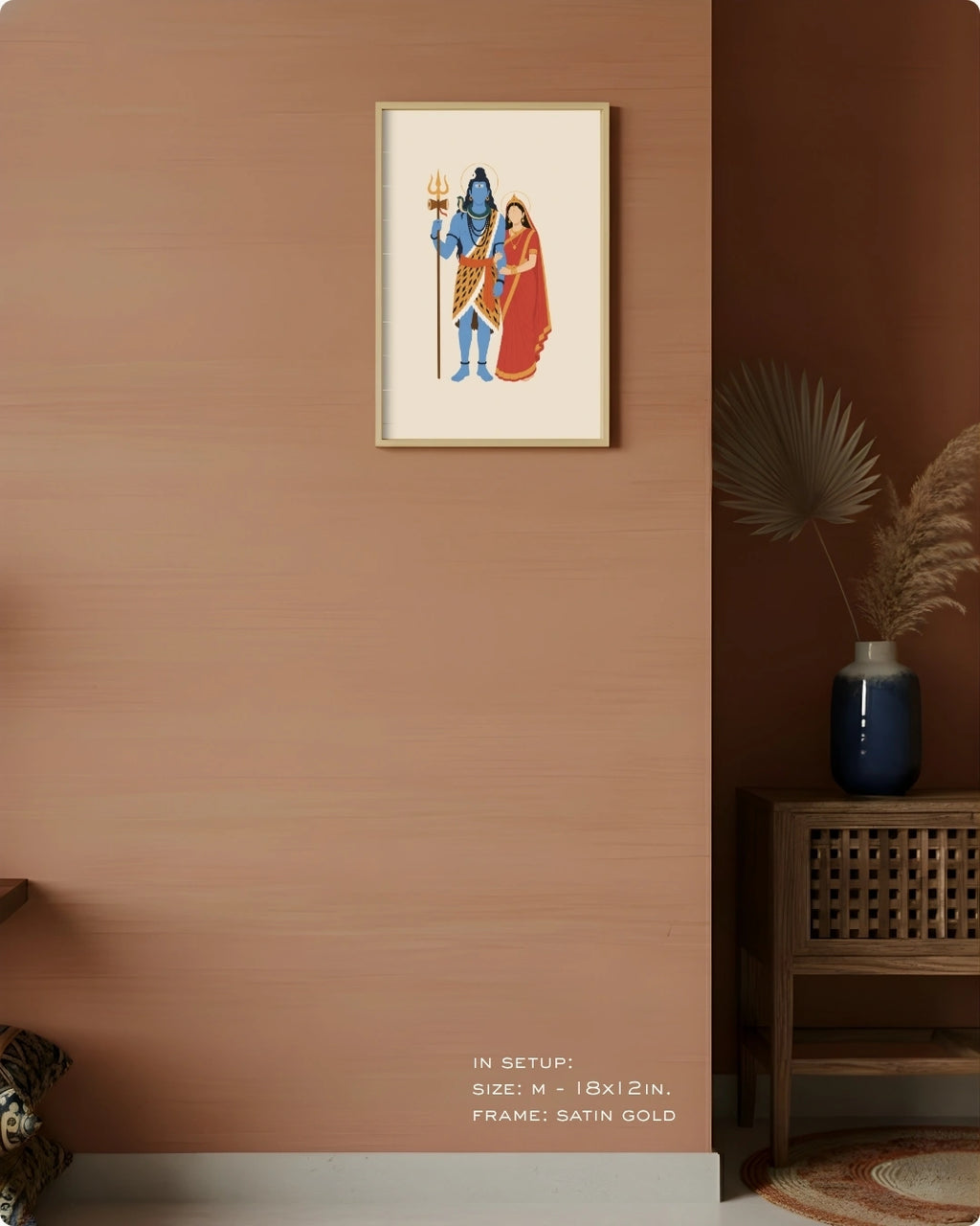 Visual size guide mockup for the Hindu divine couple Shiva and Parvati wall art in Medium size with a satin gold frame, displayed against a warm terracotta accent wall.