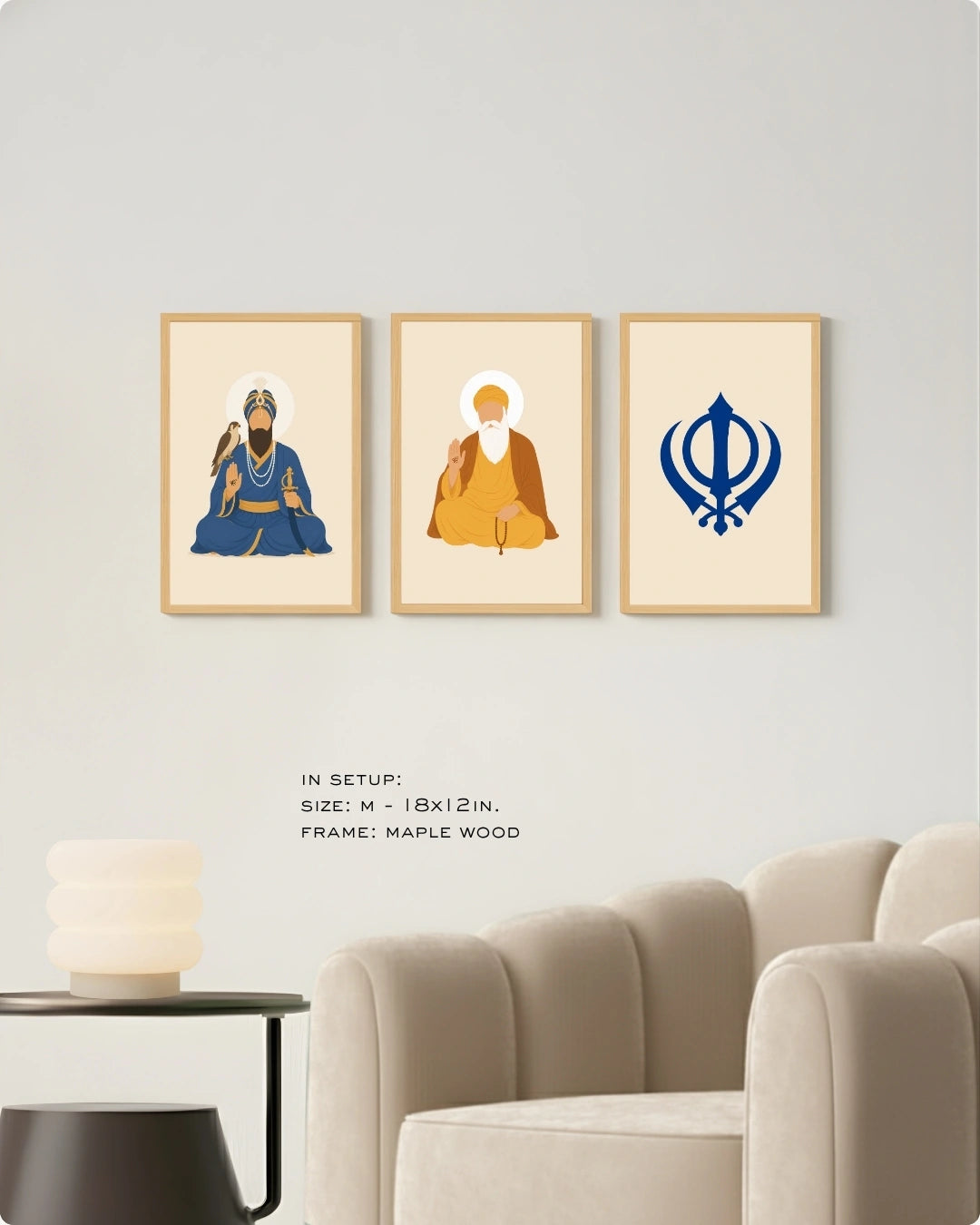 Visual size guide mockup for the Sikh Triad 3-piece wall art set in Medium size with satin gold frames, displayed above a modern ribbed beige armchair.