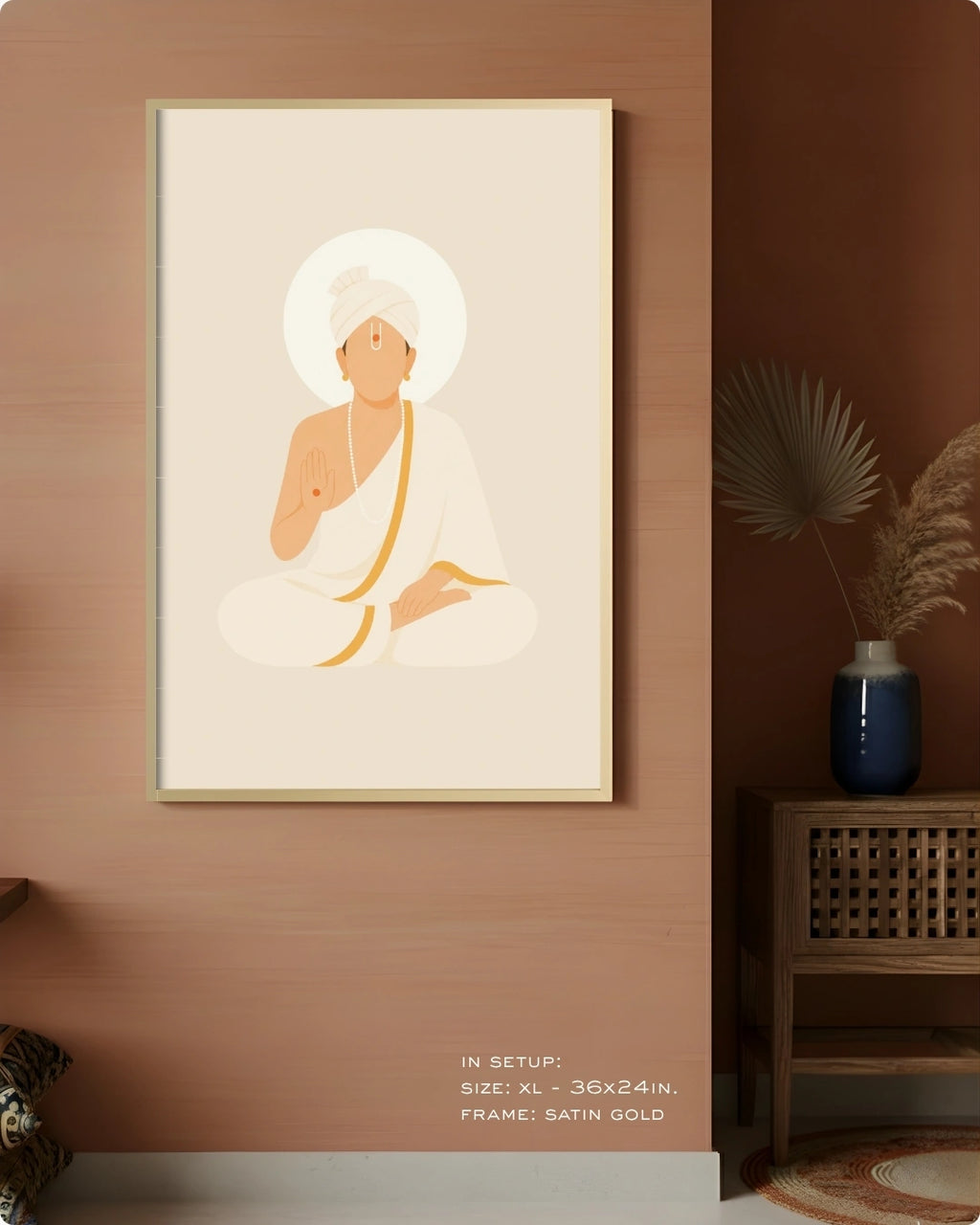 A framed minimalist art print of Swaminarayan in white and gold tones, displayed on a warm terracotta wall in a styled interior setting with a side table and vase.