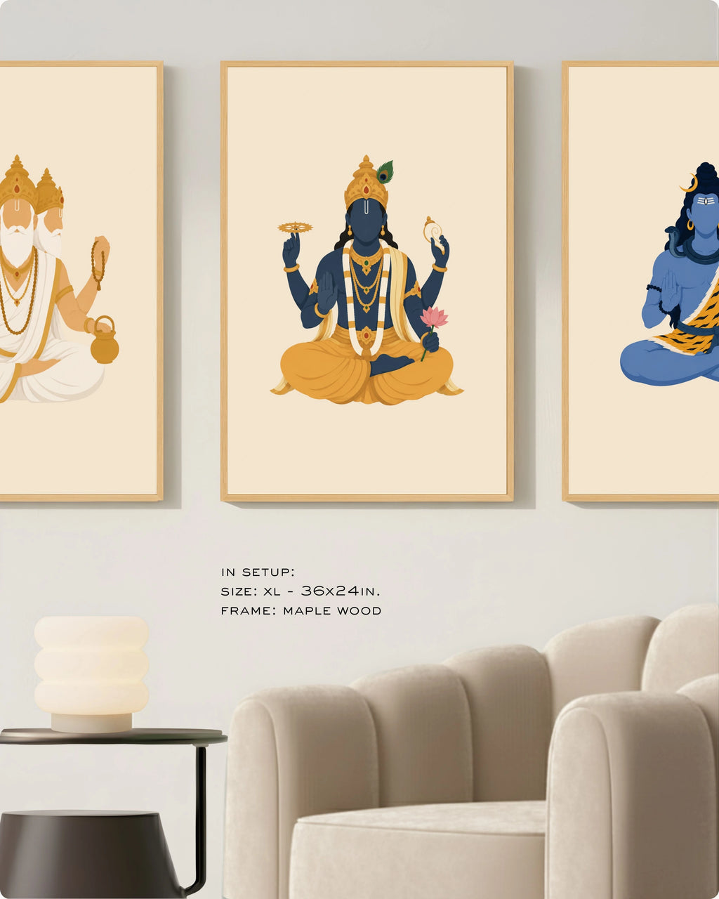 Visual size guide mockup for the Hindu Trimurti wall art set of 3 in size Extra Large (36x24 inches) with maple wood frames, shown scaled perfectly next to a contemporary beige armchair.