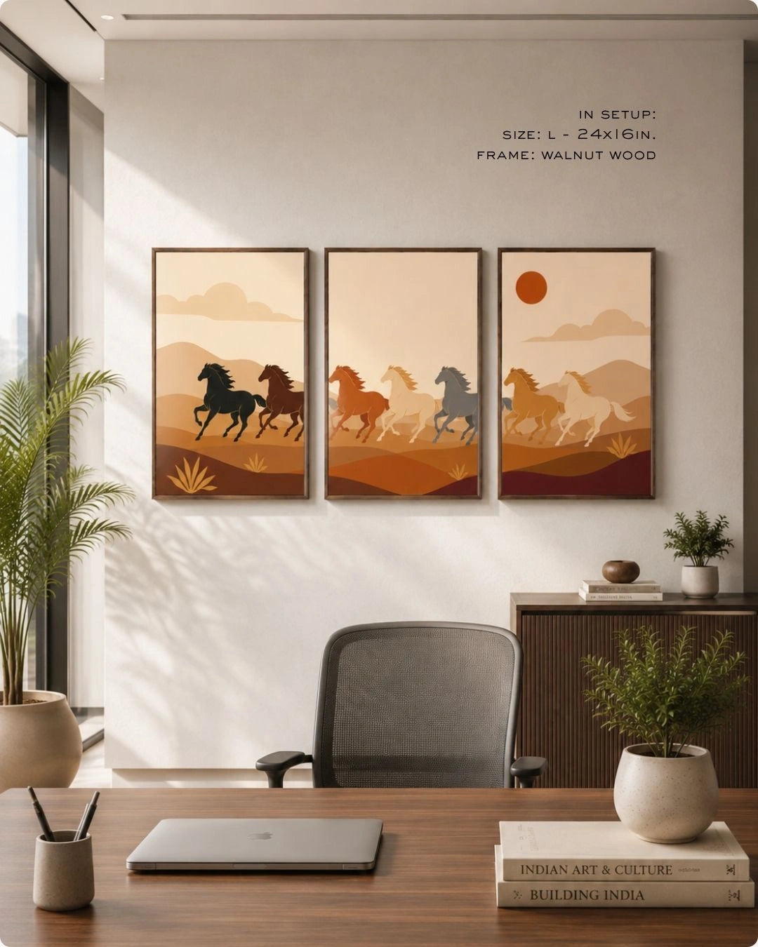 A set of three dark wood-framed wall art prints hanging in a modern, sunlit home office. The triptych features minimalist stylized horses running through an earth-toned desert landscape. In the foreground is a wooden desk with a modern grey office chair, a laptop, stacked books, and potted plants.
