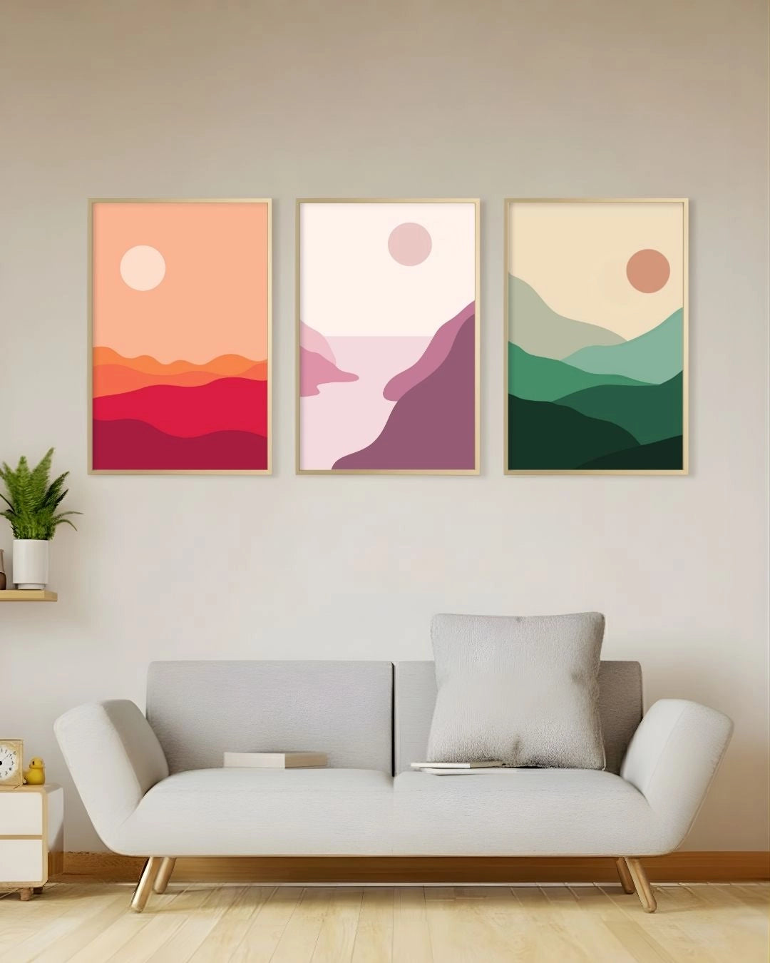A 3-piece minimalist abstract landscape gallery wall set by K2C Co. in Satin Gold frames, featuring terracotta, blush, and sage green designs above a modern grey sofa.