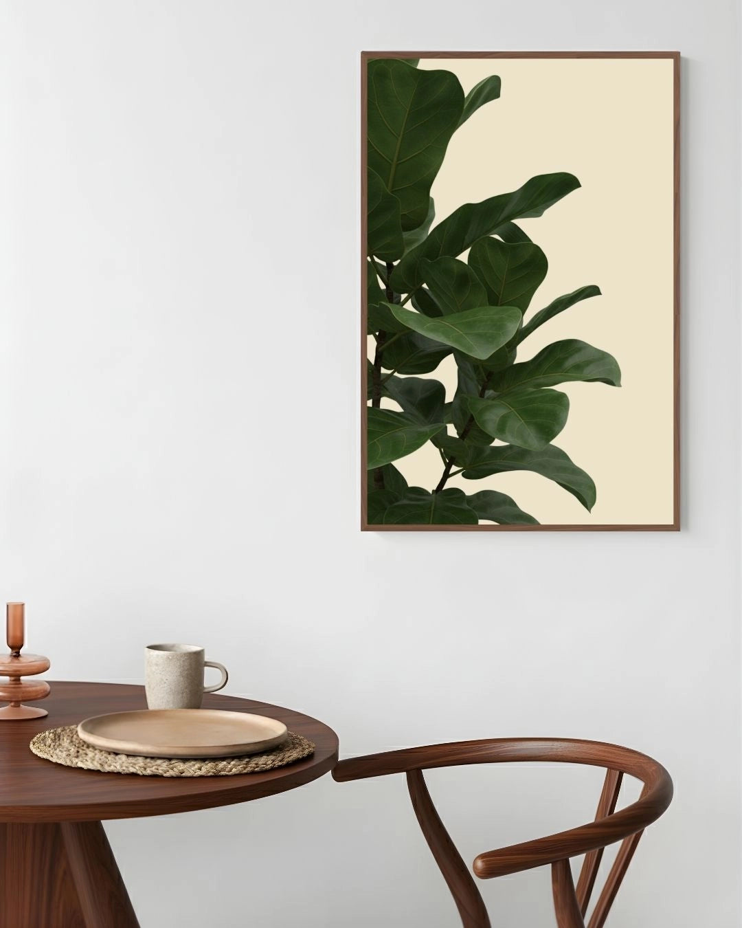 Framed plant print on a wall above a wooden table with decor items.