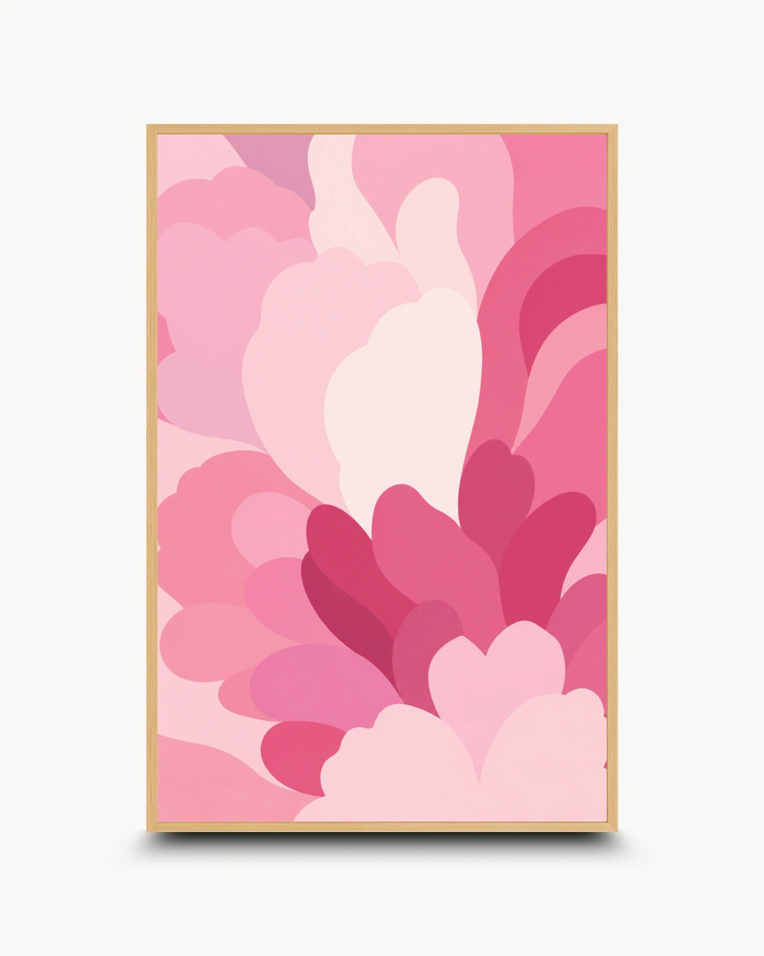 A framed abstract art print featuring layered, organic petal-like shapes in various shades of pink, from pale blush to deep magenta, set in a light wood frame against a clean off-white background.